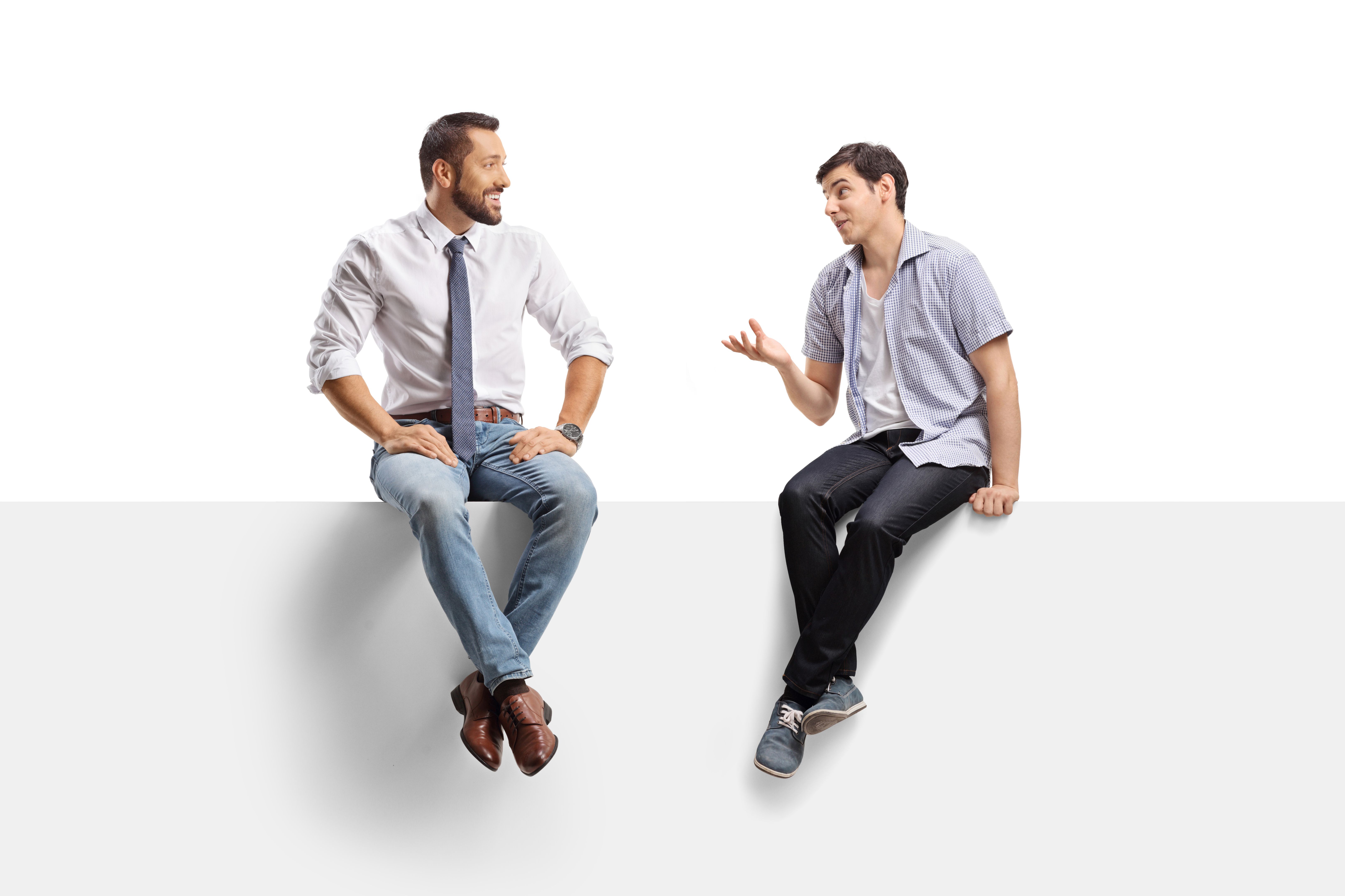 Two young men sitting on a panel and discussing