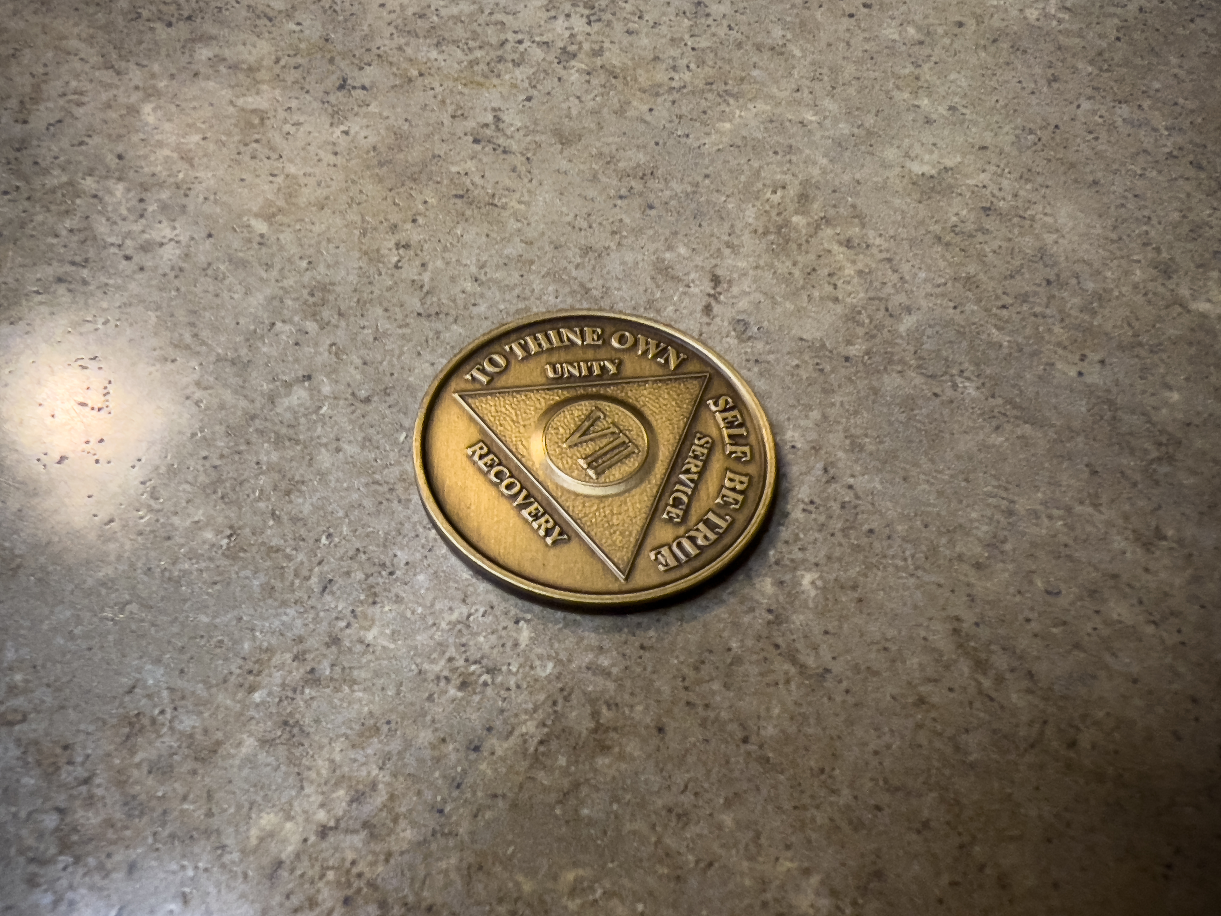 Close up view of an addiction recovery chip on a kitchen counter top Close up view of an addiction recovery chip on a kitchen counter top