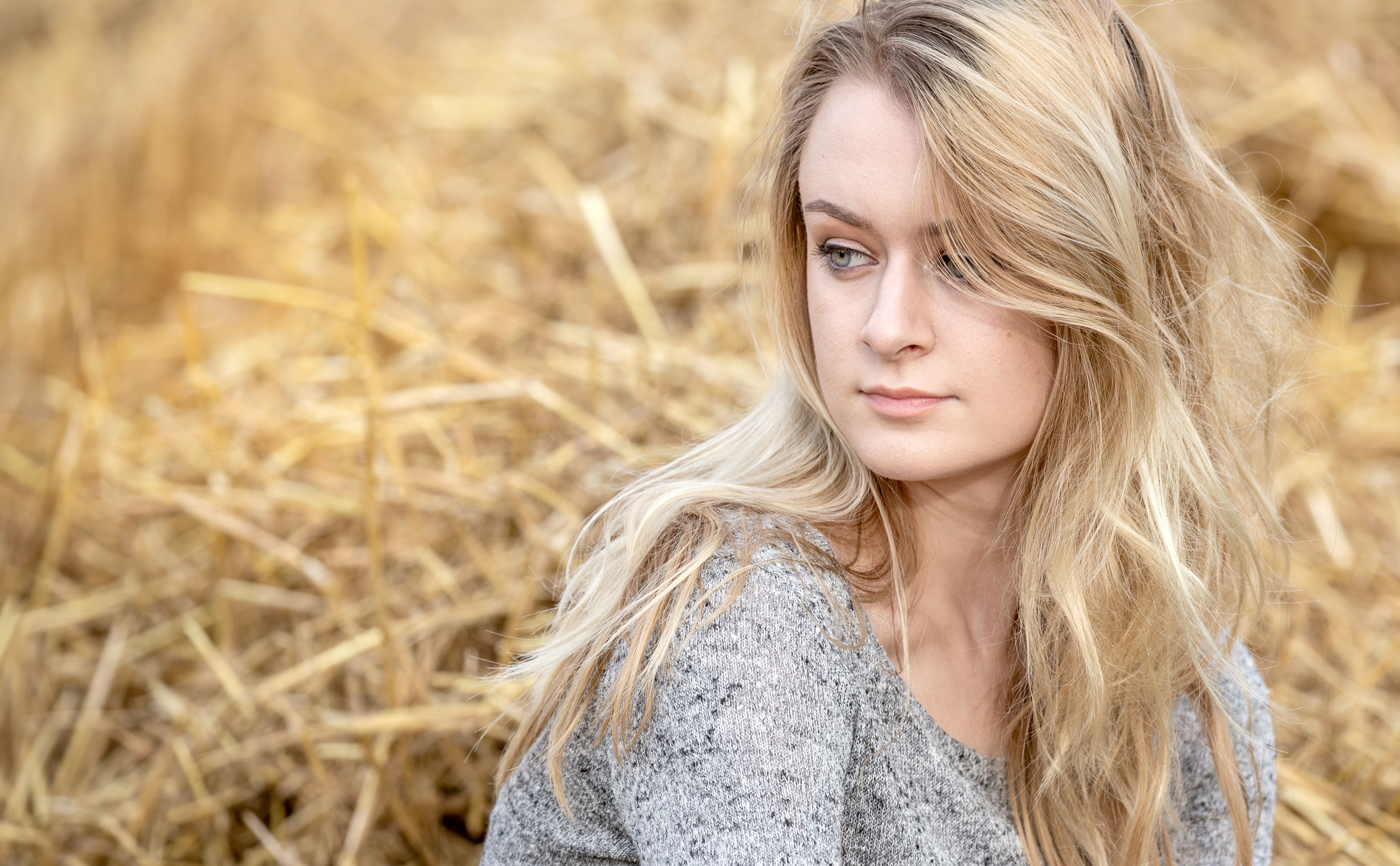 Portrait of a pretty blond teenage girl in a cornfield bathed in soft summer evening sunshine