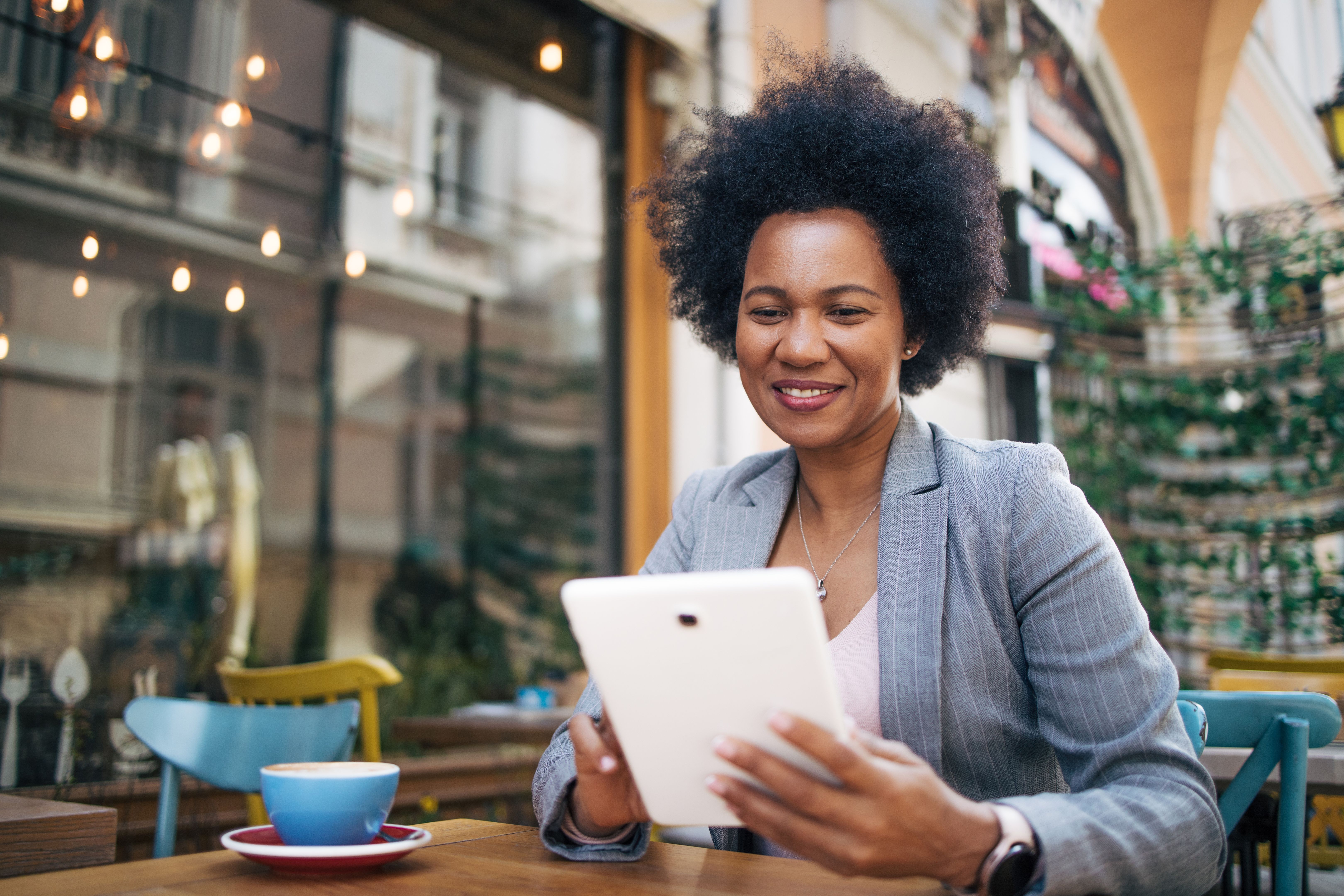 Businesswoman sitting at a coffee shop using digital tablet