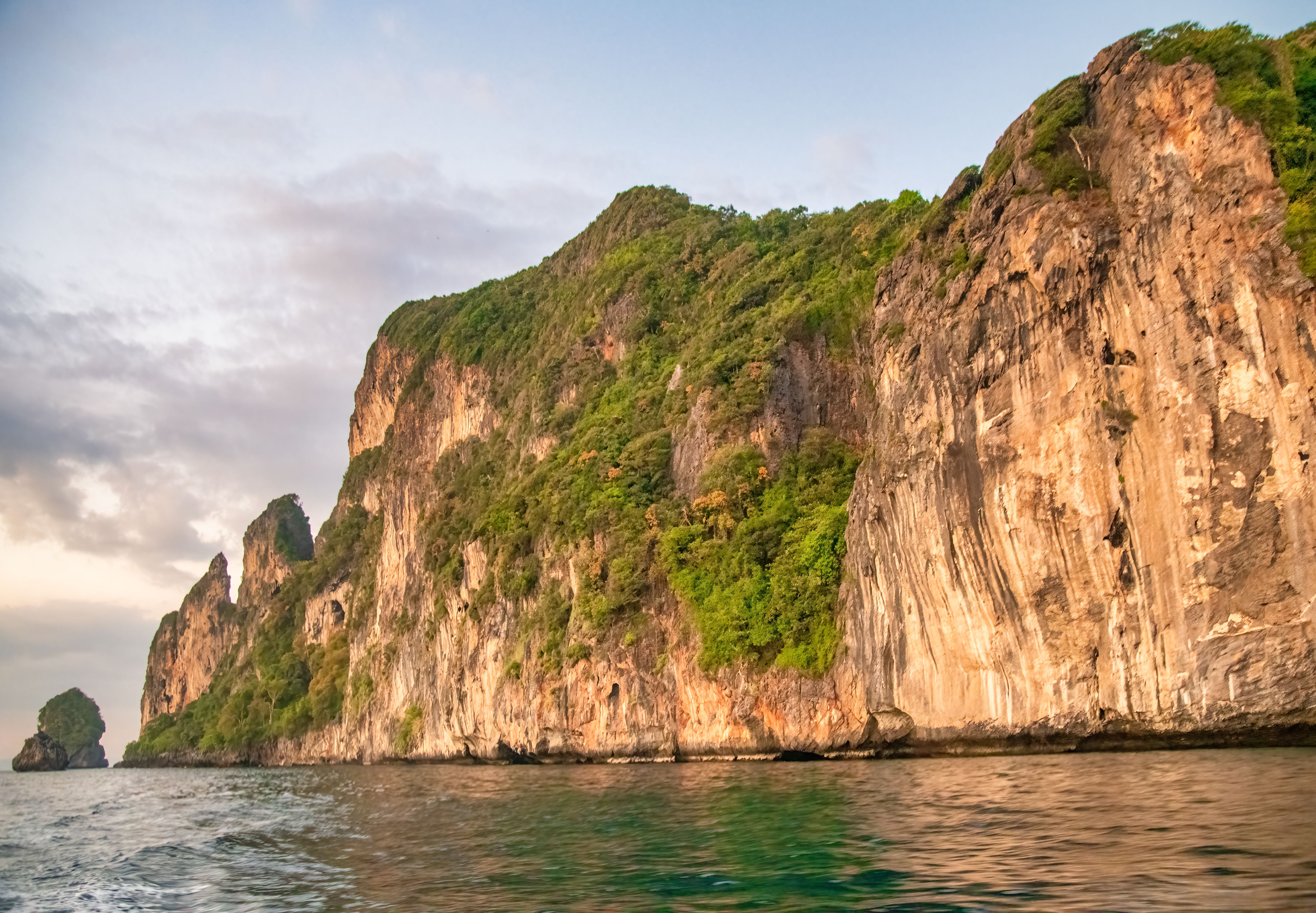 Long-tail boats silhouetted against a stunning sunset at Nui Beach, Phi Phi Don