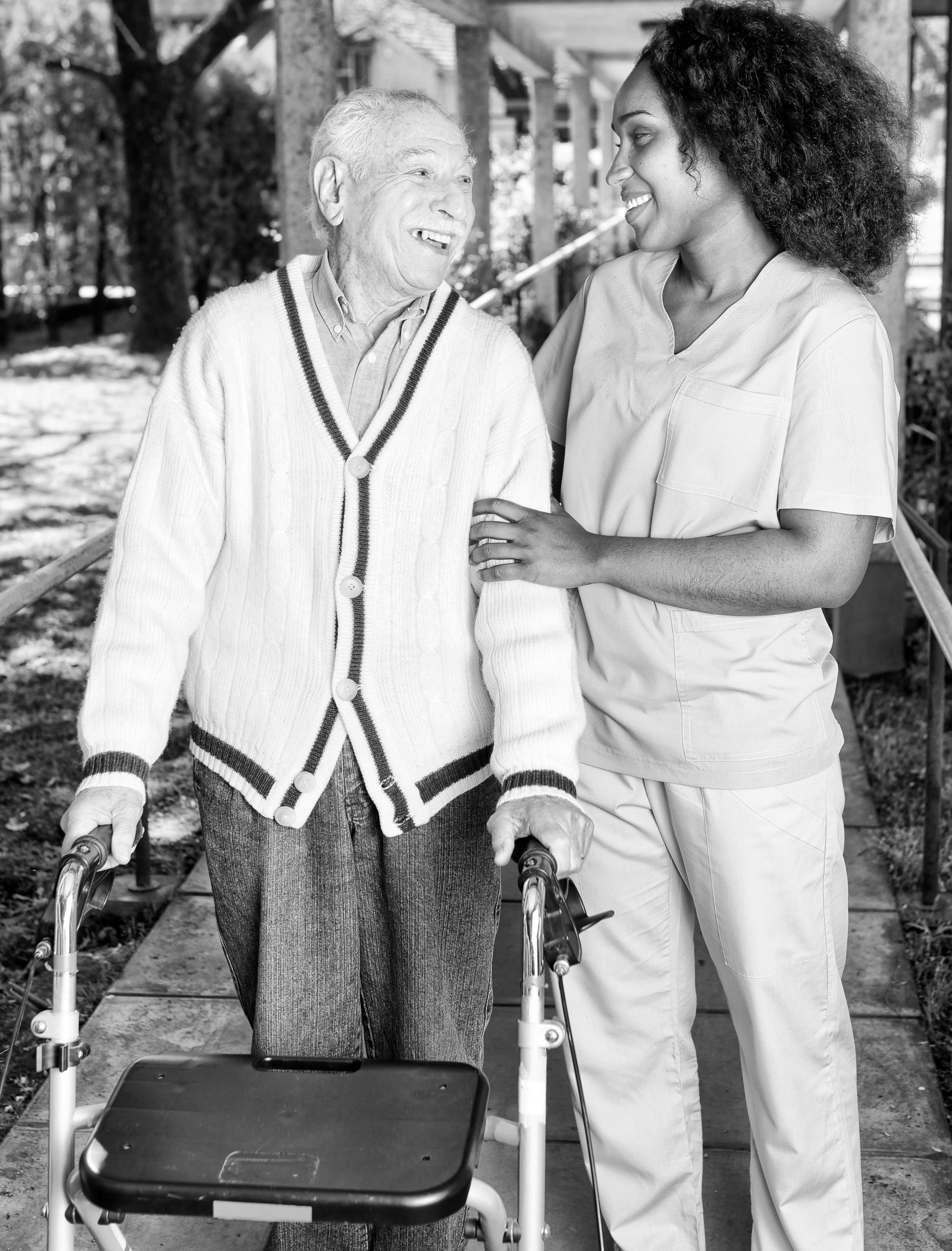 Health care worker assisting elderly client with walker