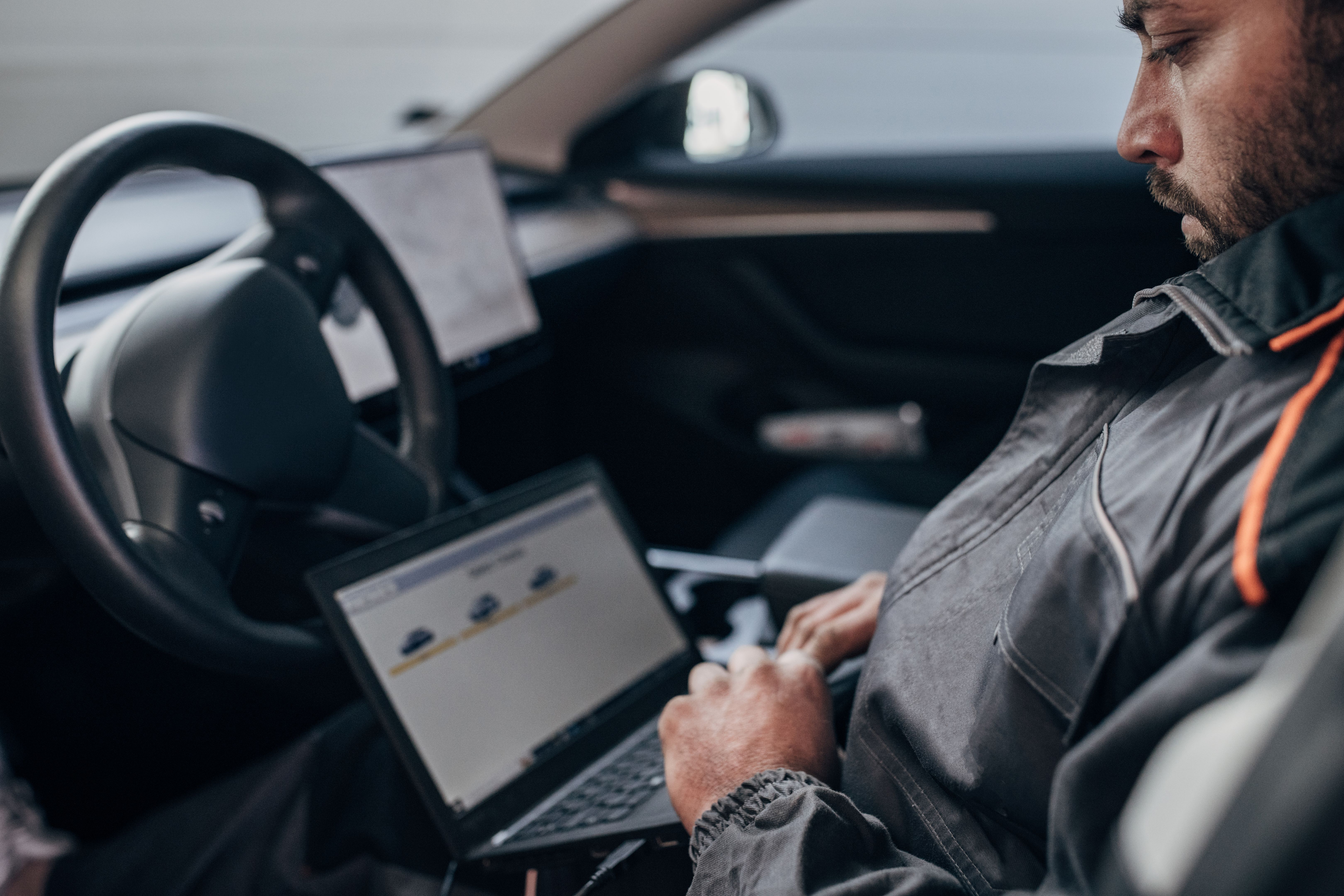 Mécanicien faisant le diagnostic de voiture dans l’atelier de réparation d’automobile
