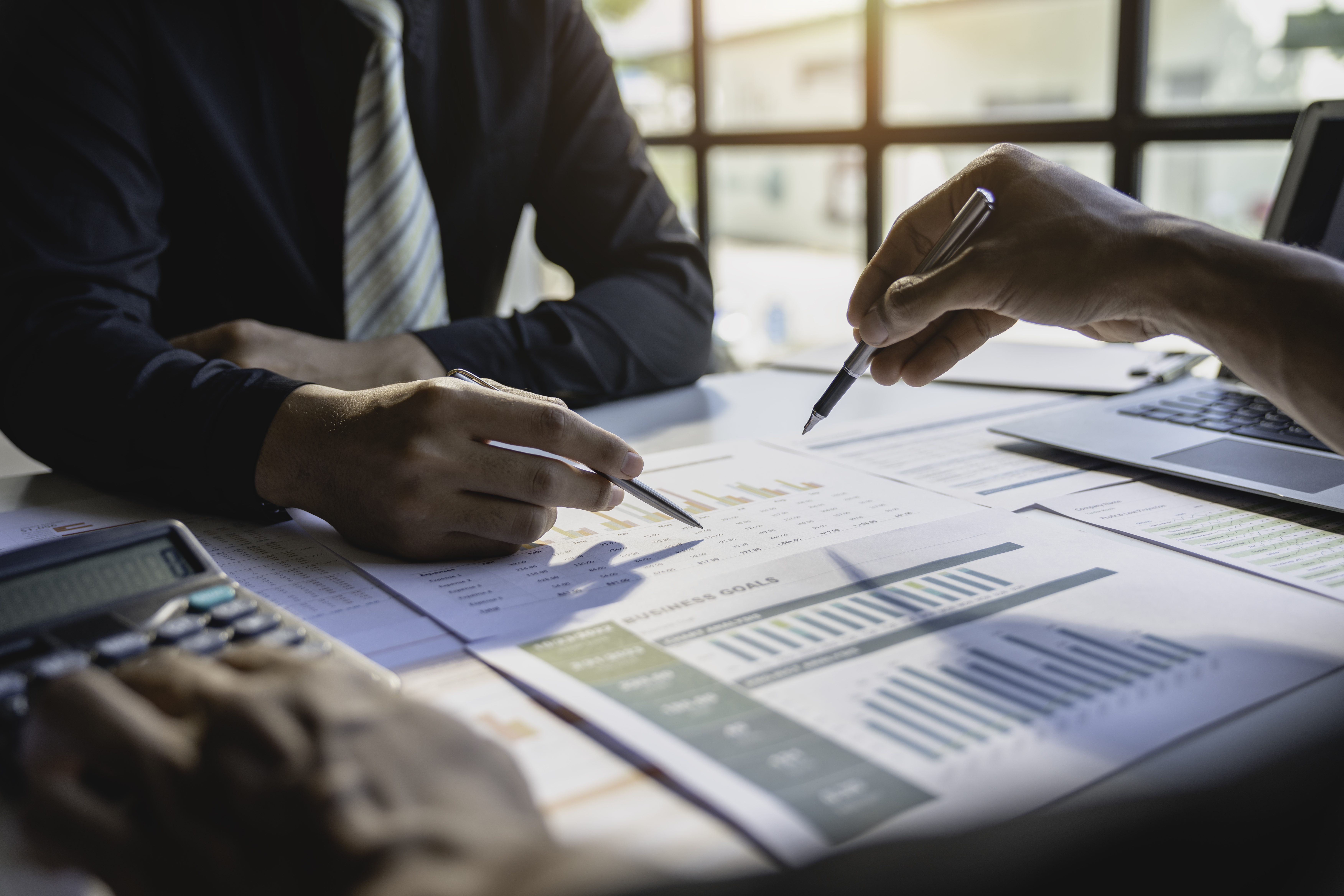 Teamwork with business people analysis cost graph on the desk in the meeting room. The business team discussed meetings and briefing strategies. Negotiation, Analysis, Discussion Teamwork with business people analysis cost graph on the desk in the meeting room. The business team discussed meetings and briefing strategies. Negotiation, Analysis, Discussion