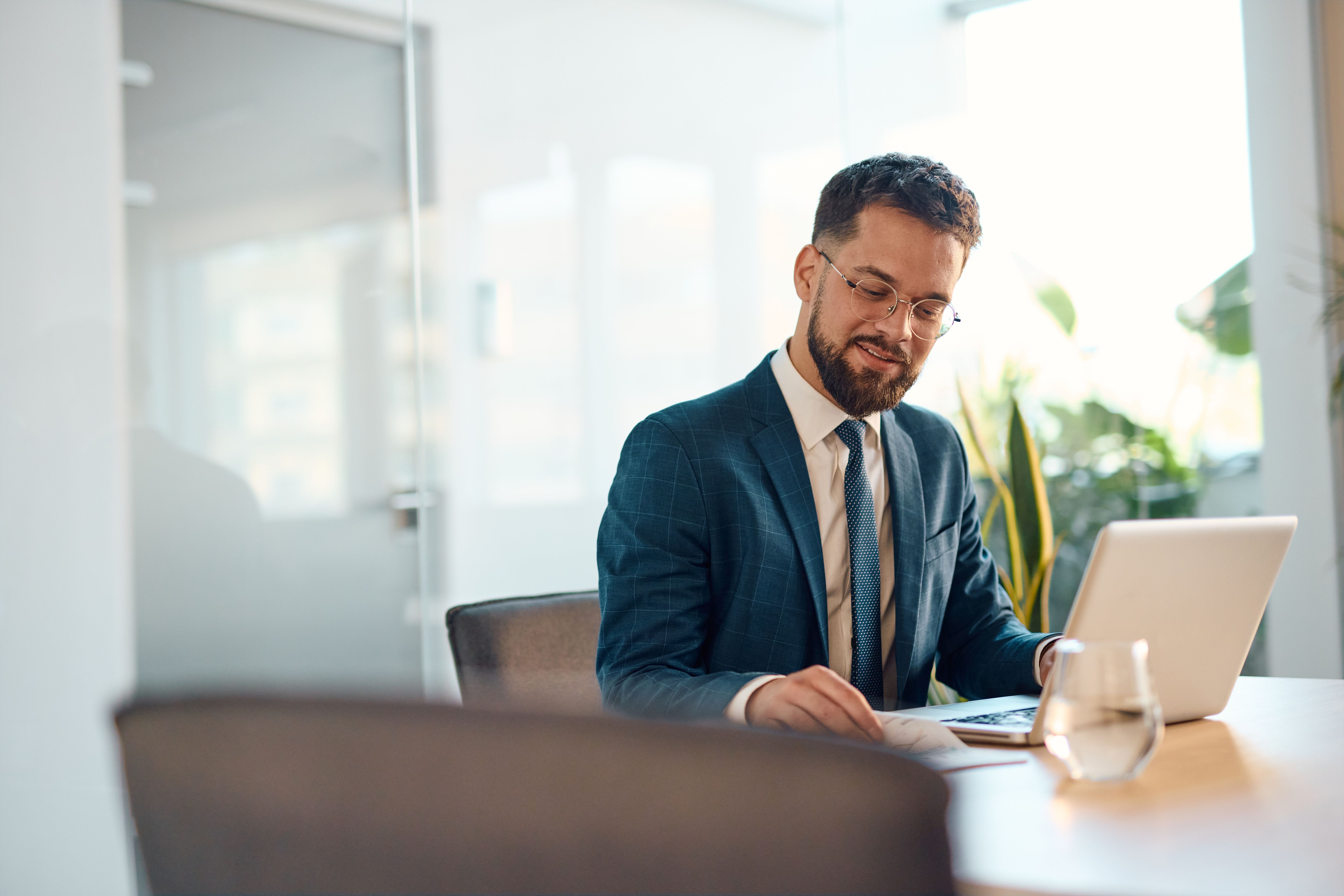 Businessman working with laptop and documents in modern office Businessman working with laptop and documents in modern office