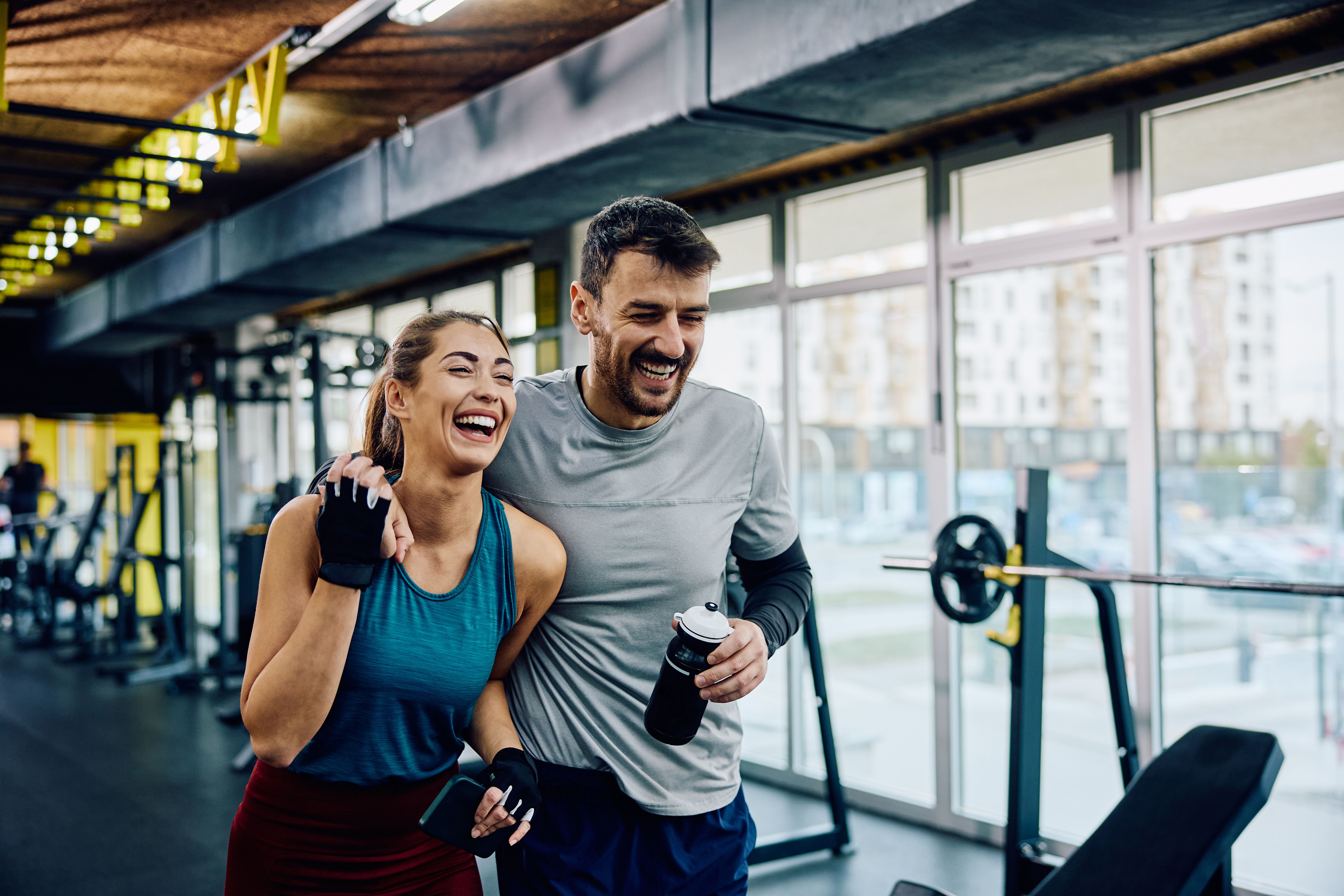 Cheerful athletic couple having sports training in a gym. Cheerful athletic couple having sports training in a gym.