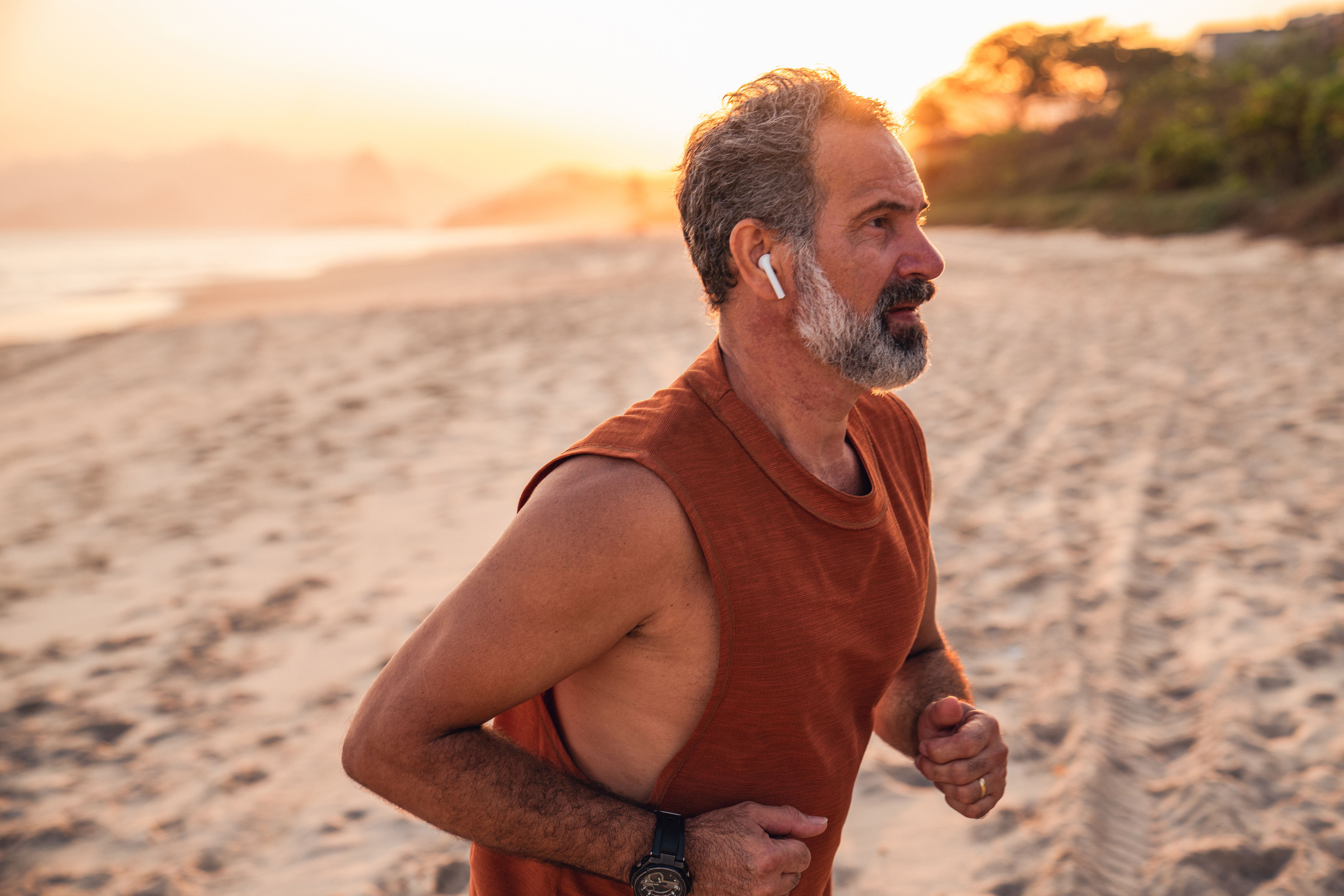 An active senior enjoys jogging on the beach