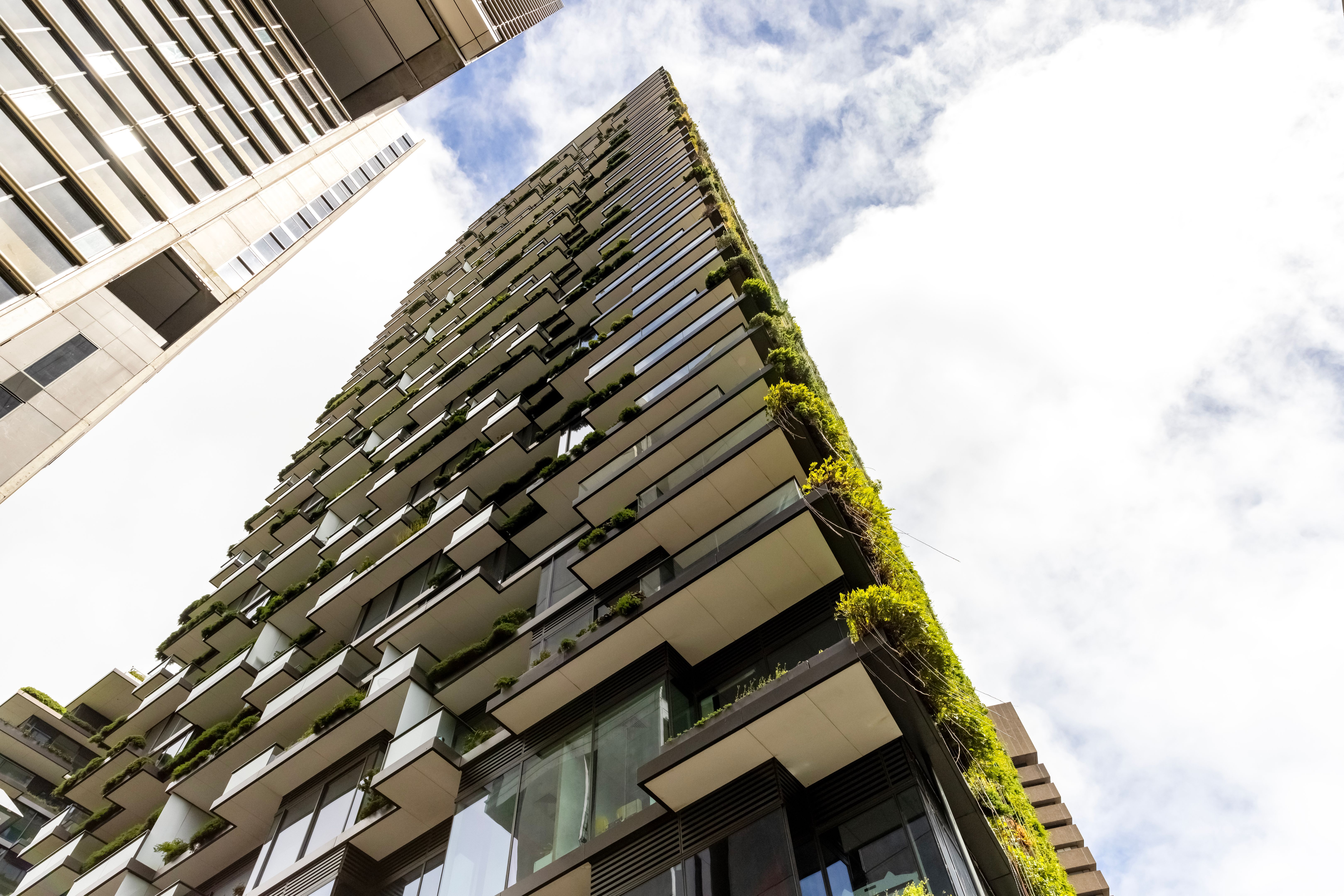 Low angle view of apartment building with vertical gardens, sky background with copy space Low angle view of apartment building with vertical gardens, sky background with copy space