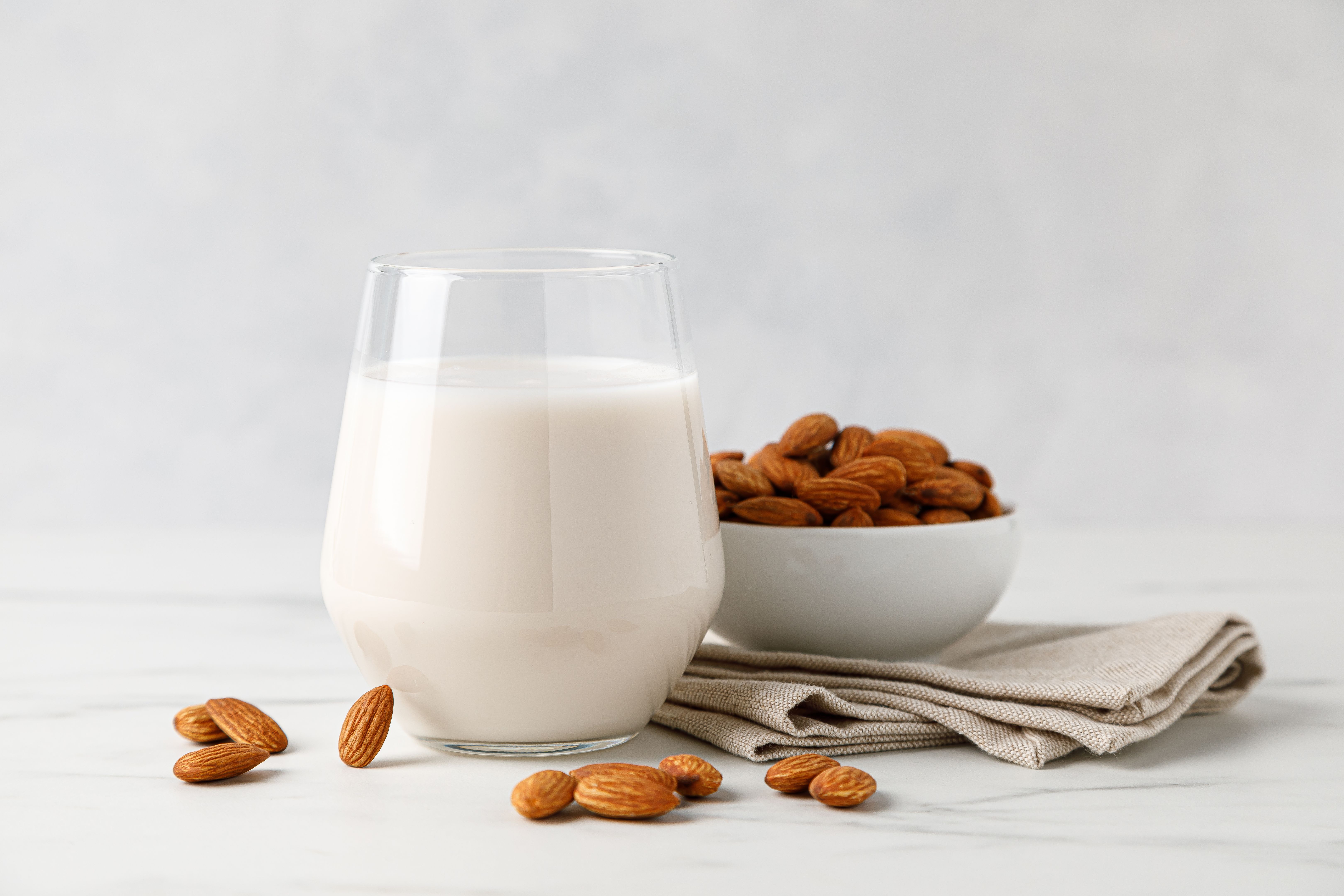 Almond milk in a glass and almond nuts