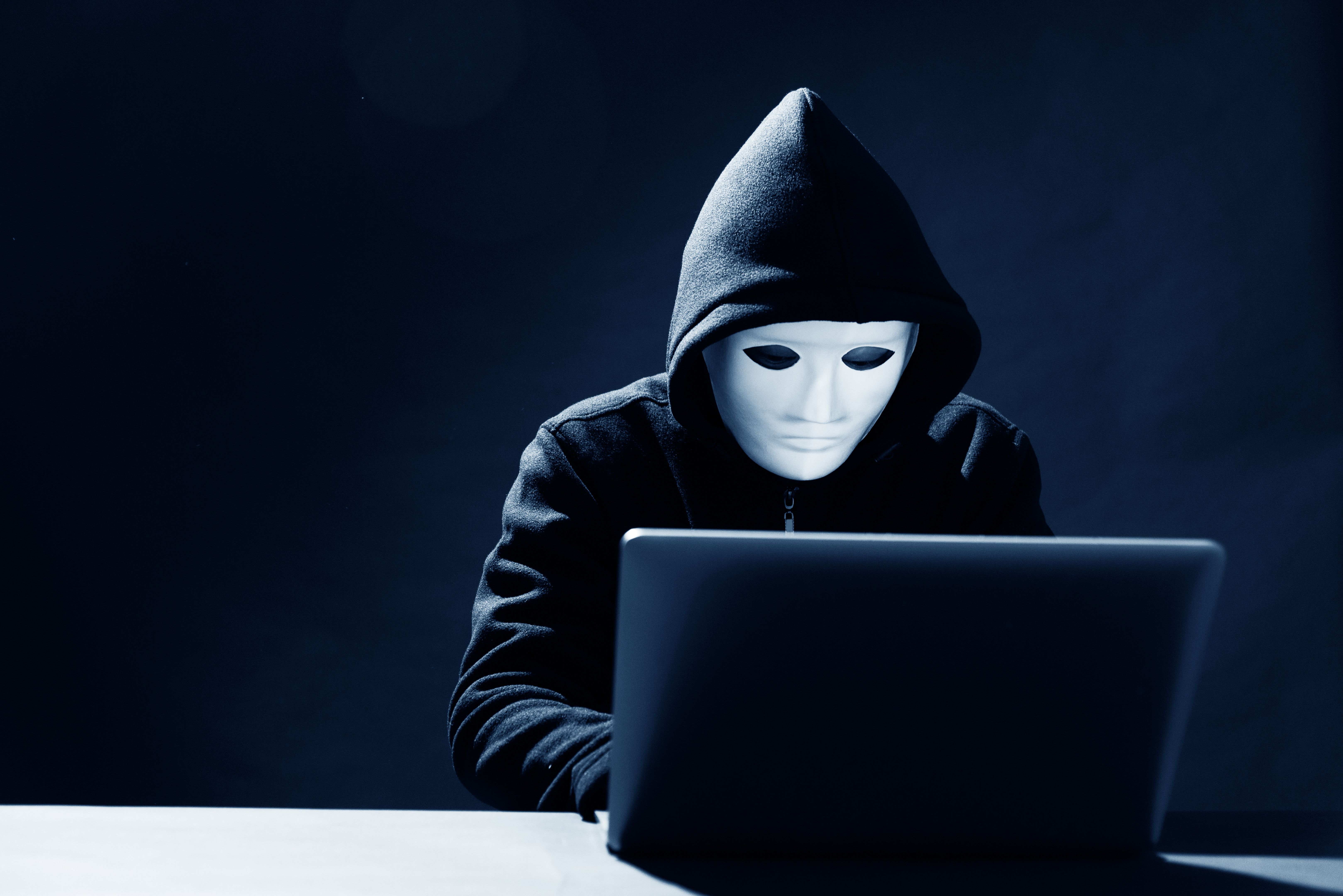 Hacher with a mask is using laptop Hacher with a mask is using laptop