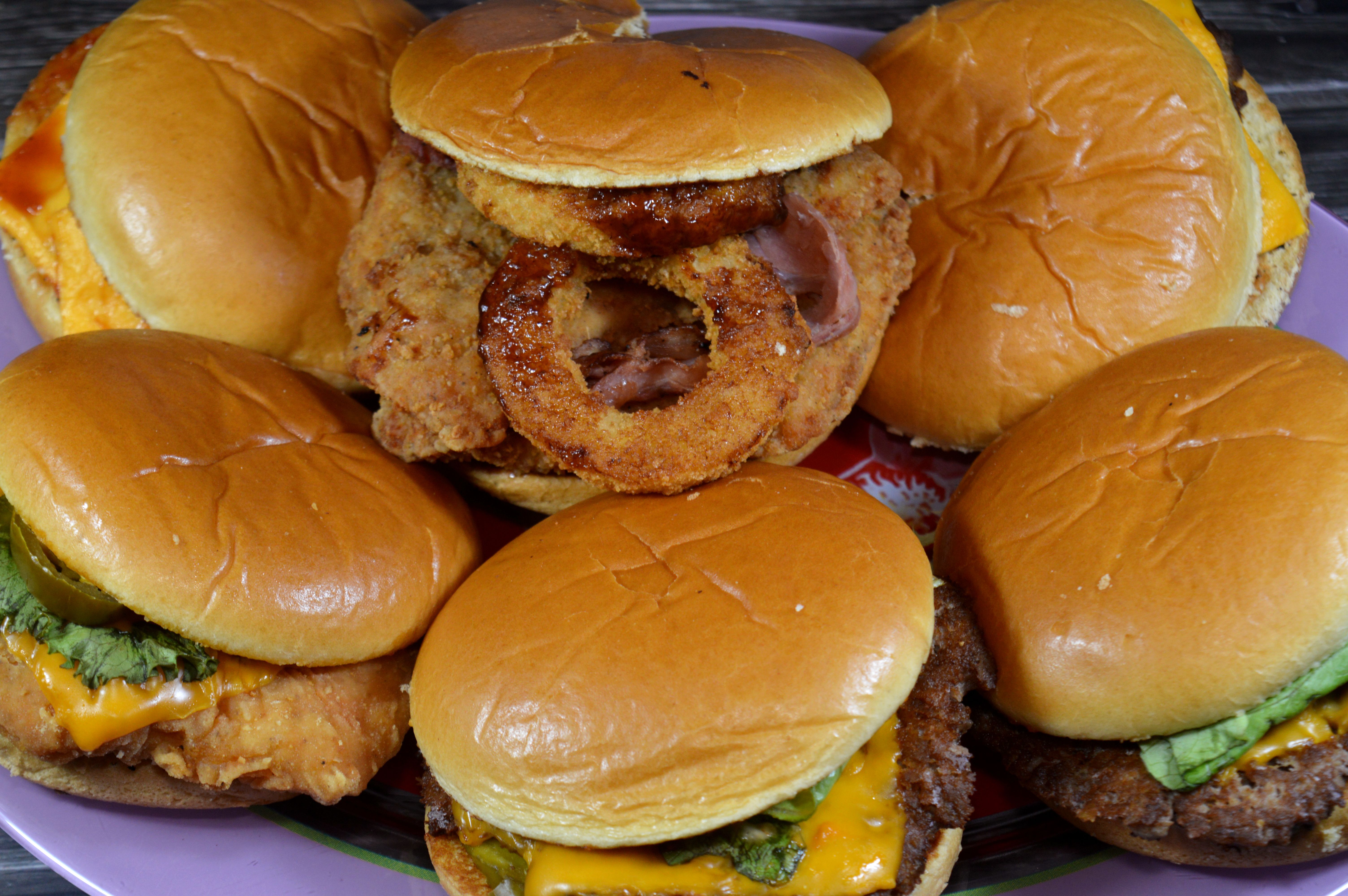 Assorted sandwiches of cheeseburger, a hamburger with a slice of melted cheese on top of the meat patty, chicken fillet