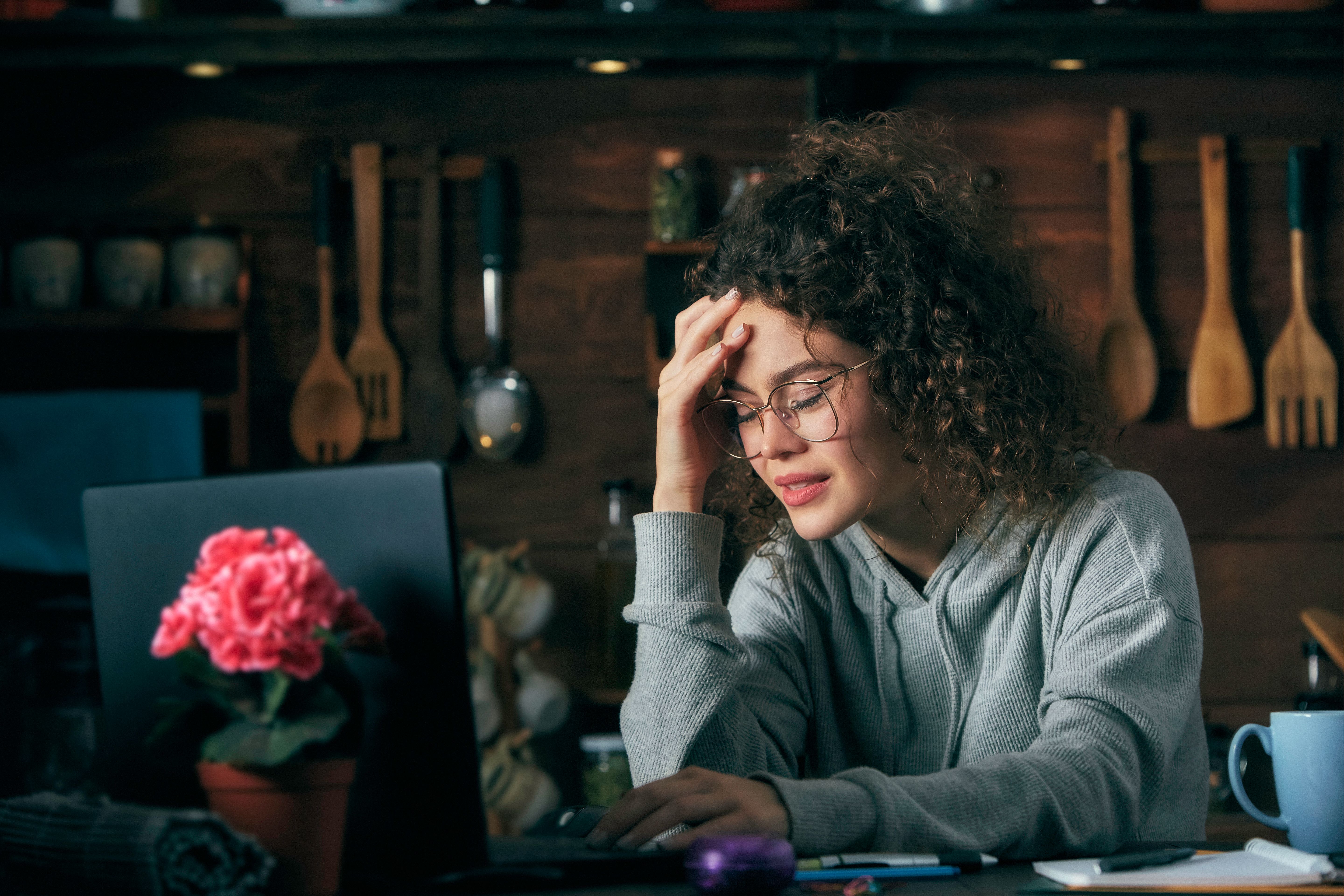 Hispanic curly hair stressed or worried young woman using laptop working at home office Hispanic curly hair stressed or worried young woman using laptop working at home office