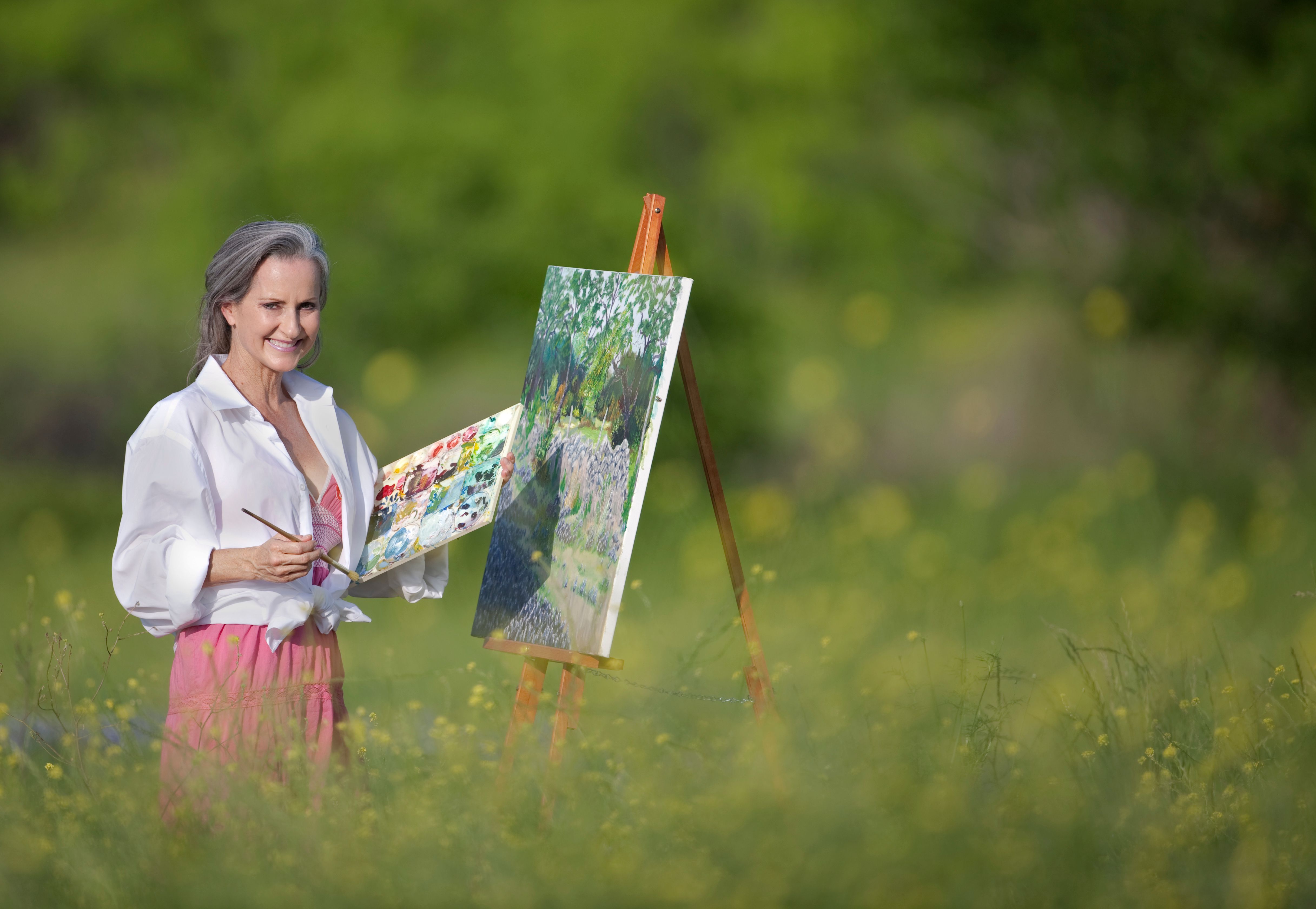 Middle Aged Woman Painting In Wildflower Garden Middle Aged Woman Painting In Wildflower Garden