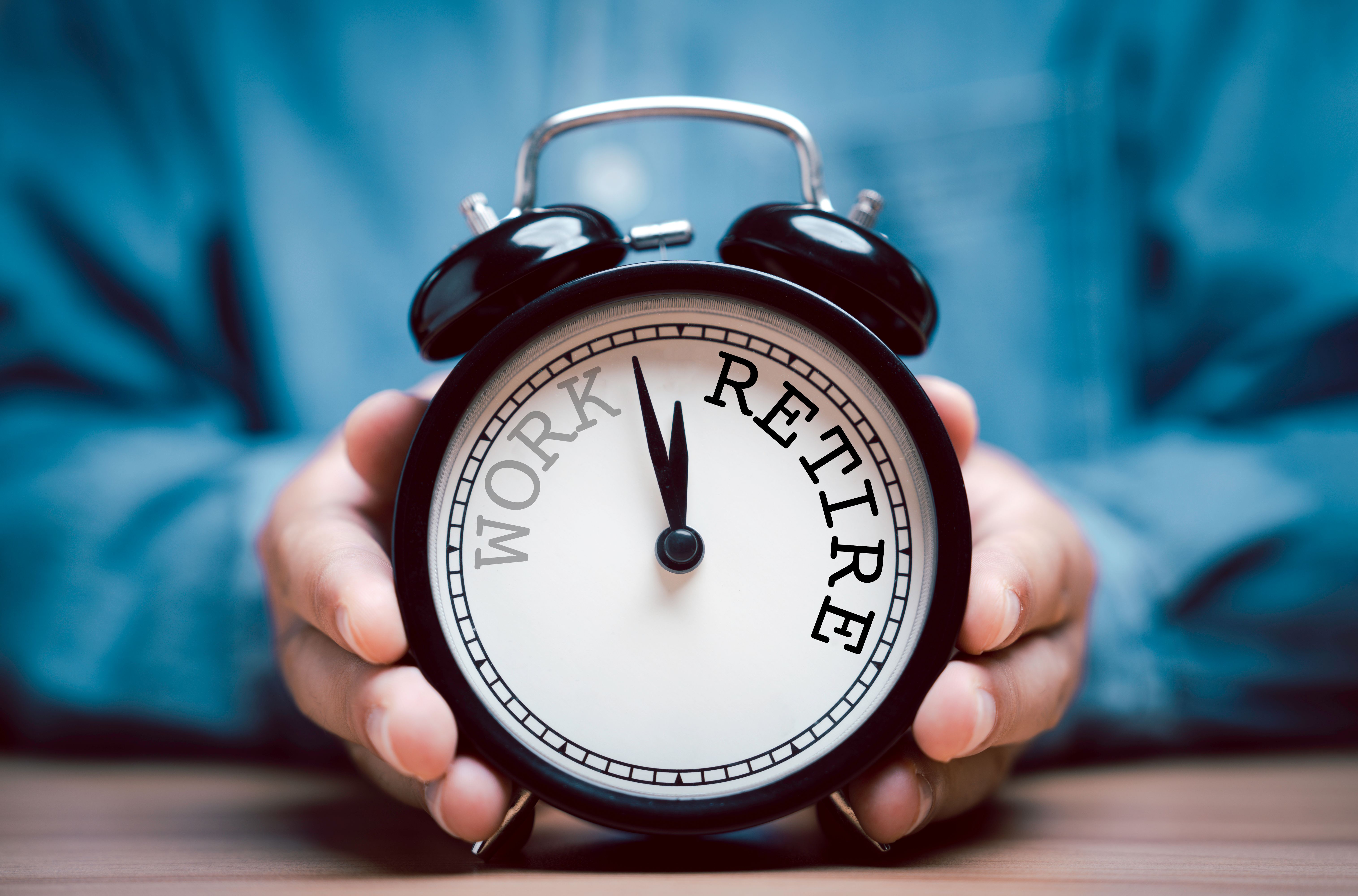 Businessman holding black alarm clock with clockwise countdown from work to retirement. Businessman holding black alarm clock with clockwise countdown from work to retirement.