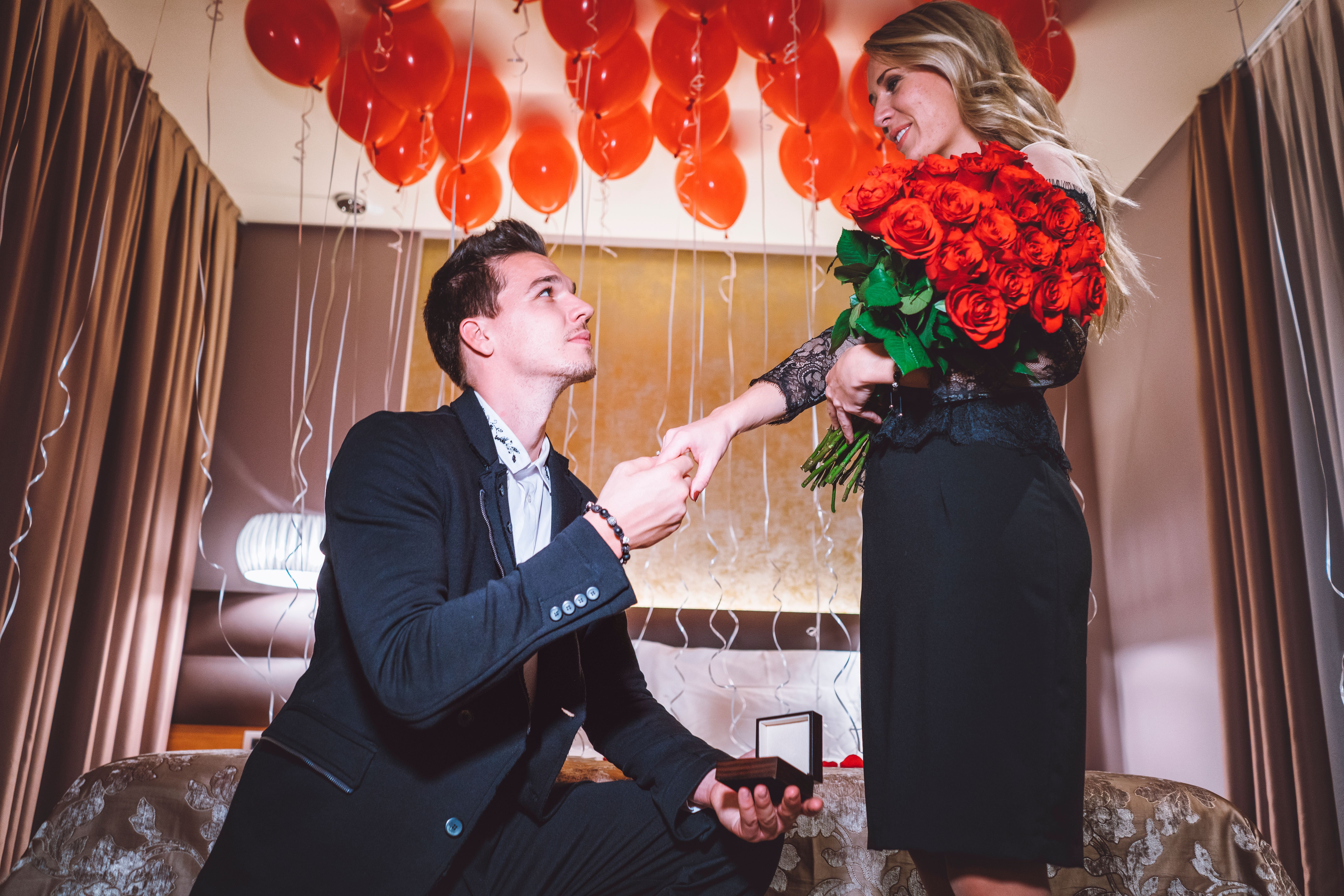 Young beautiful couple getting engaged in the luxurioius hotel