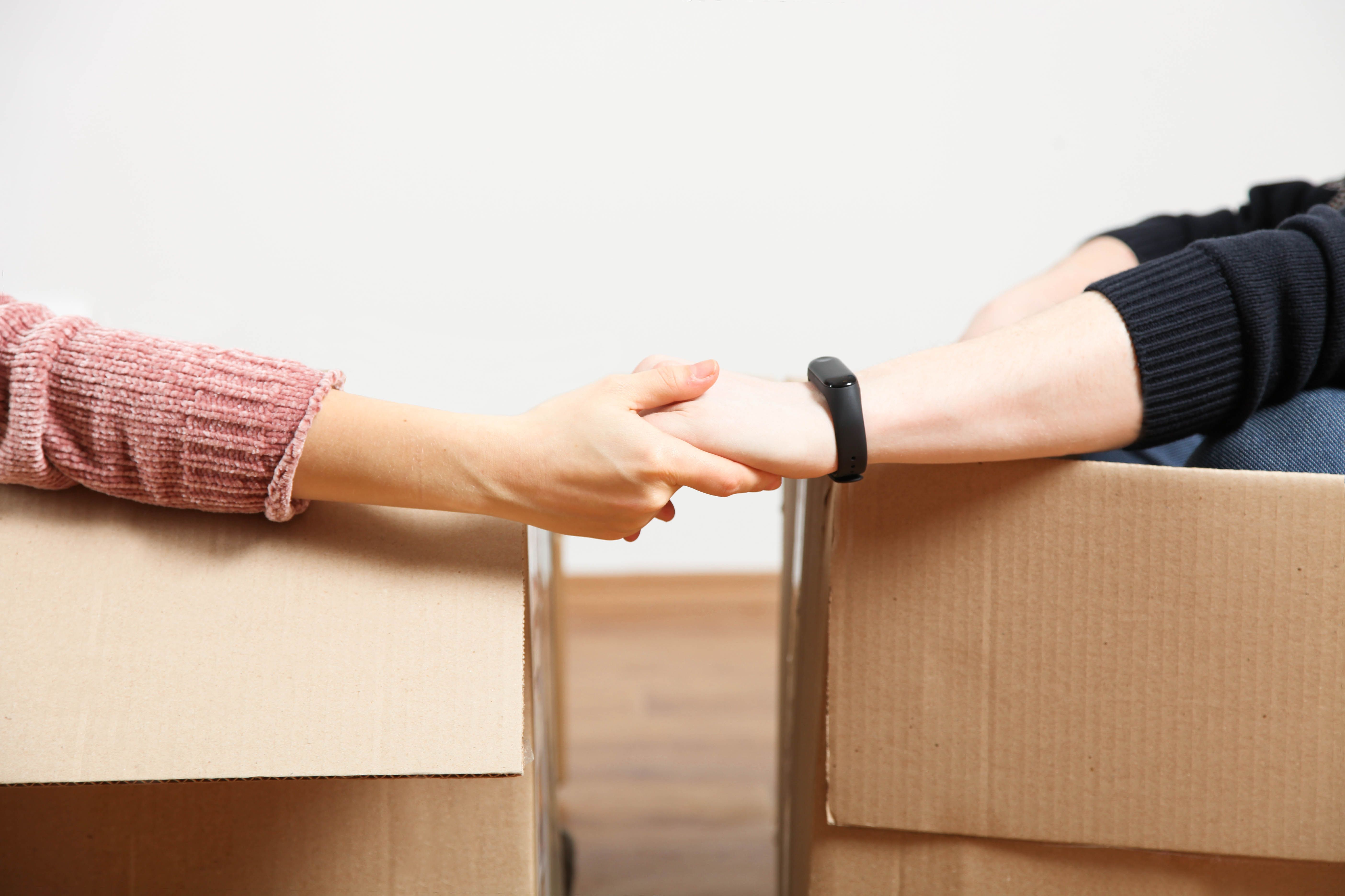 couple sit in boxes and hold hands