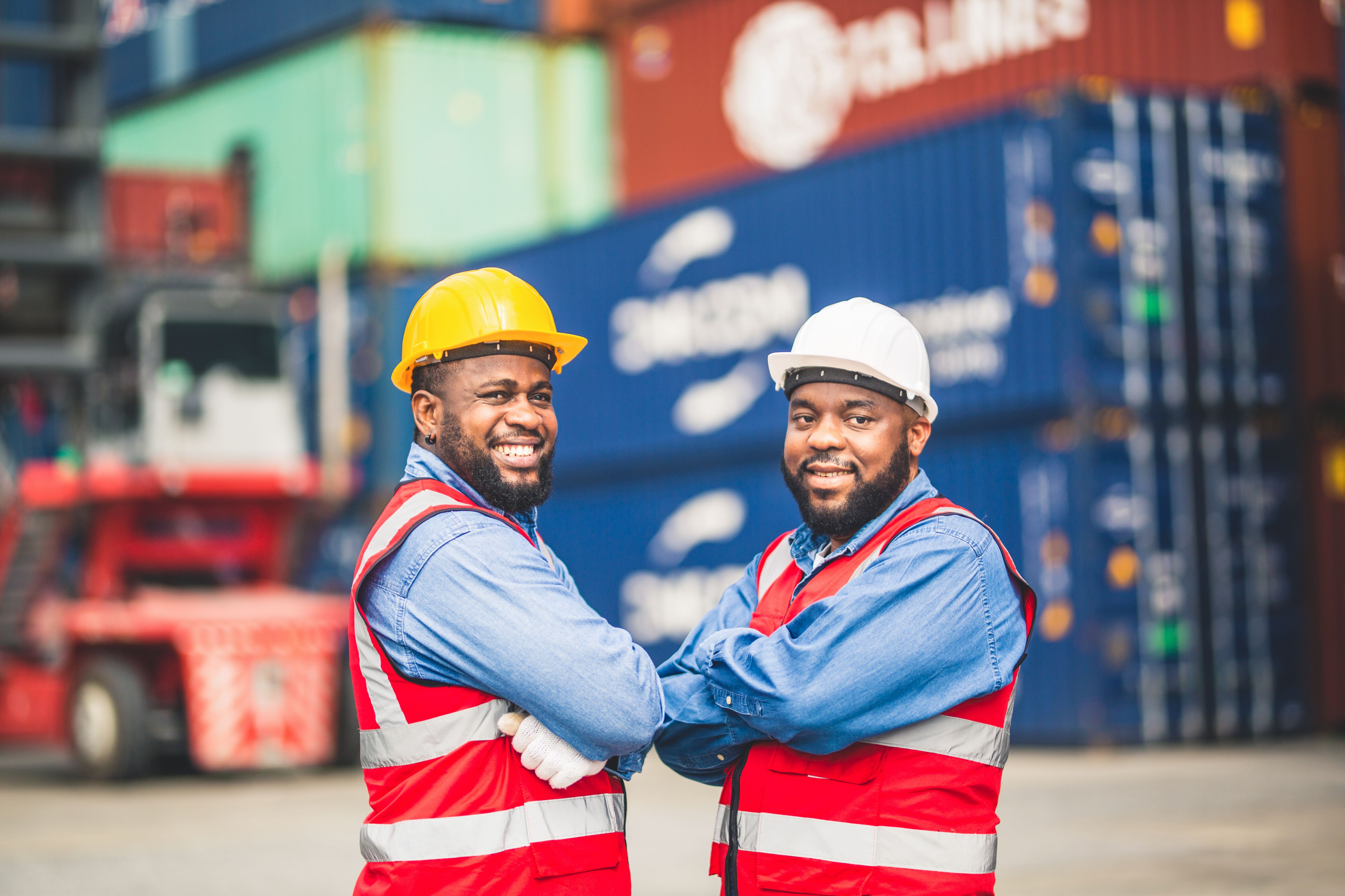 Portrait of Two African Engineer or foreman wears PPE shaking hand with cargo container background at sunset. Logistics global import or export shipping industrial concept. Portrait of Two African Engineer or foreman wears PPE shaking hand with cargo container background at sunset. Logistics global import or export shipping industrial concept.
