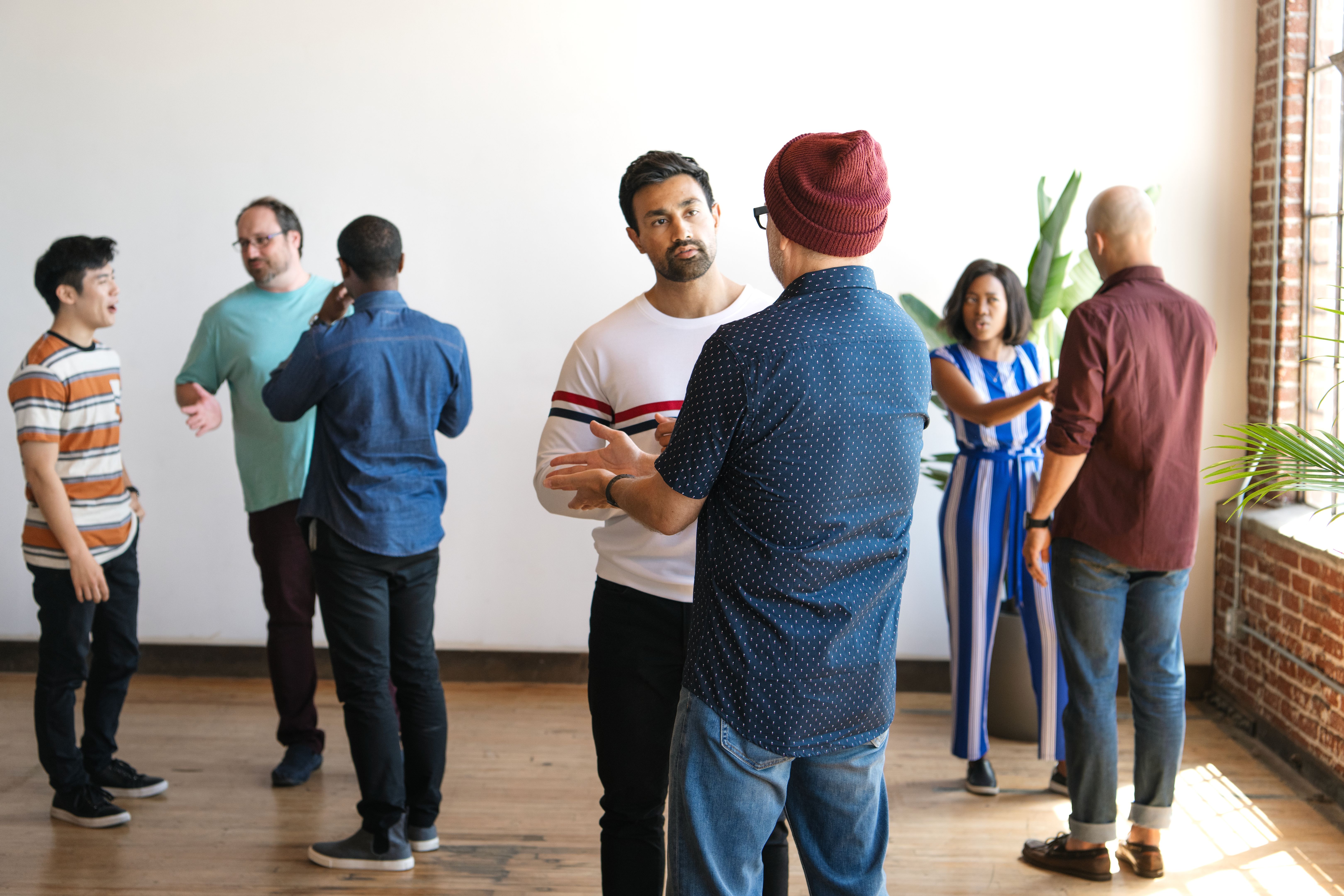 Diverse group of men and women having group conversations, team building activity.