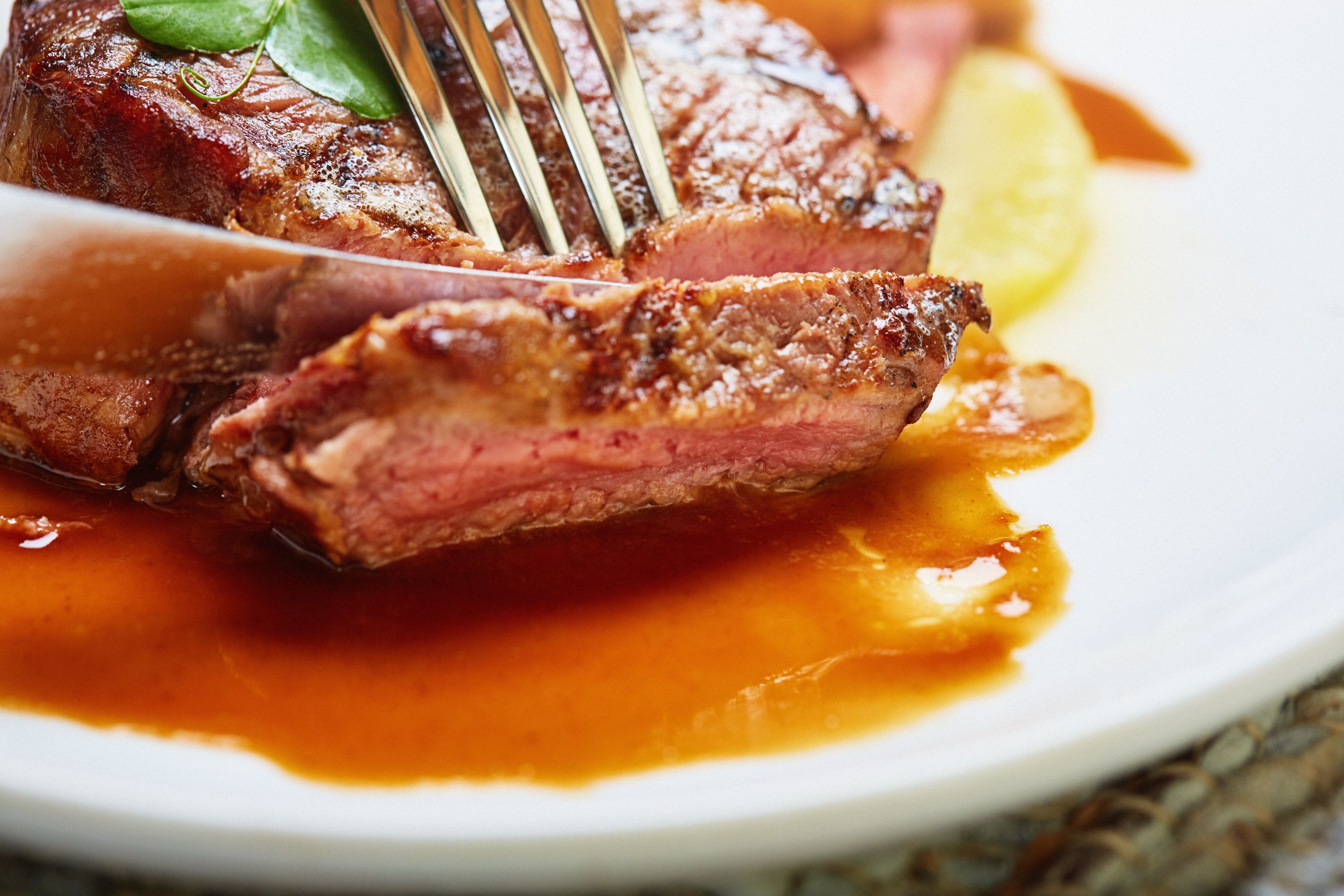 Knife and fork slicing a portion of rare fillet steak Knife and fork slicing a portion of rare fillet steak