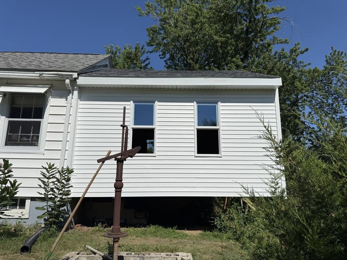 After: the finished home addition with new white vinyl siding, new windows, and a new shingle roof, built by Urban Edge Construction
