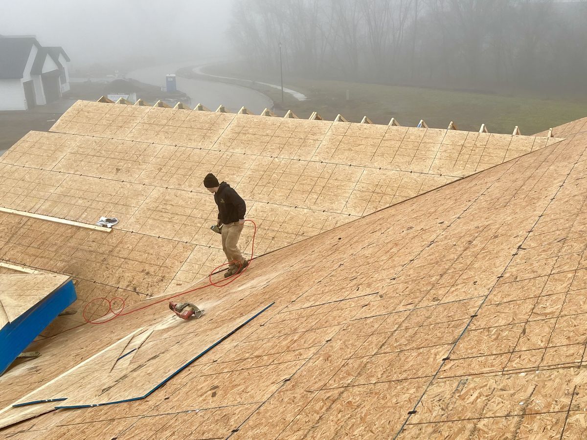 Matt laying roof decking on a Cedar Rapids roofing project