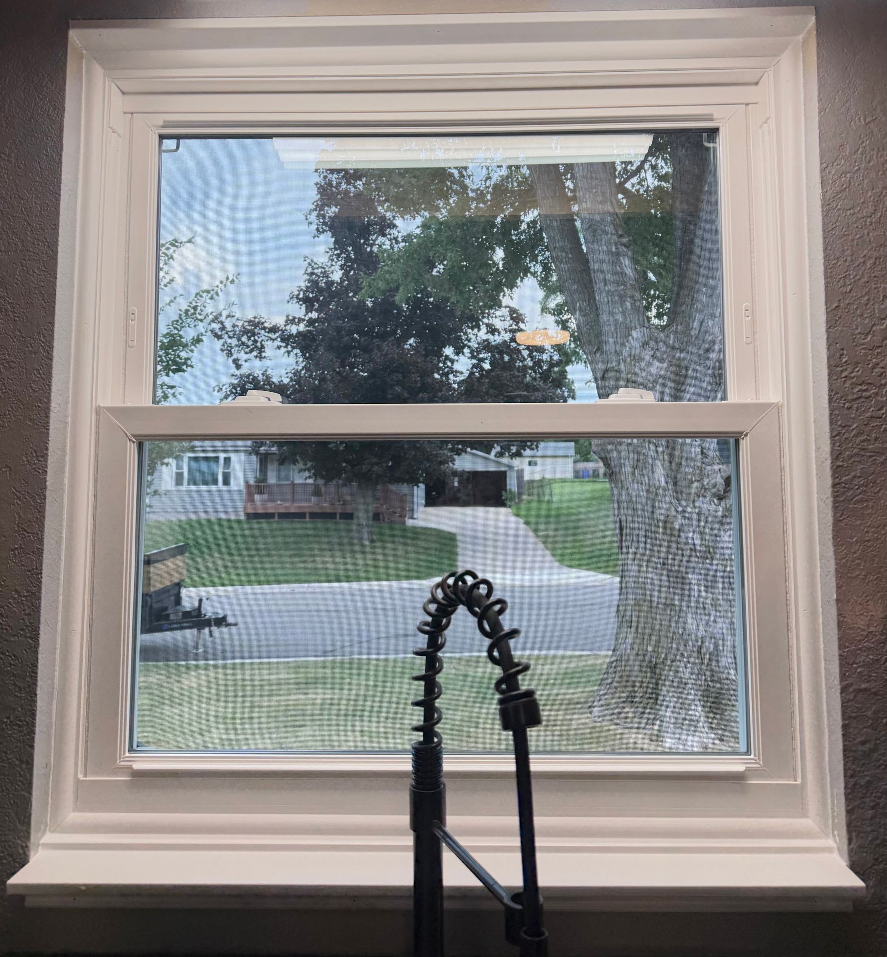 Pella vinyl slider window with a custom interior kitchen sill and trim installed by Urban Edge Construction in Cedar Rapids, Iowa