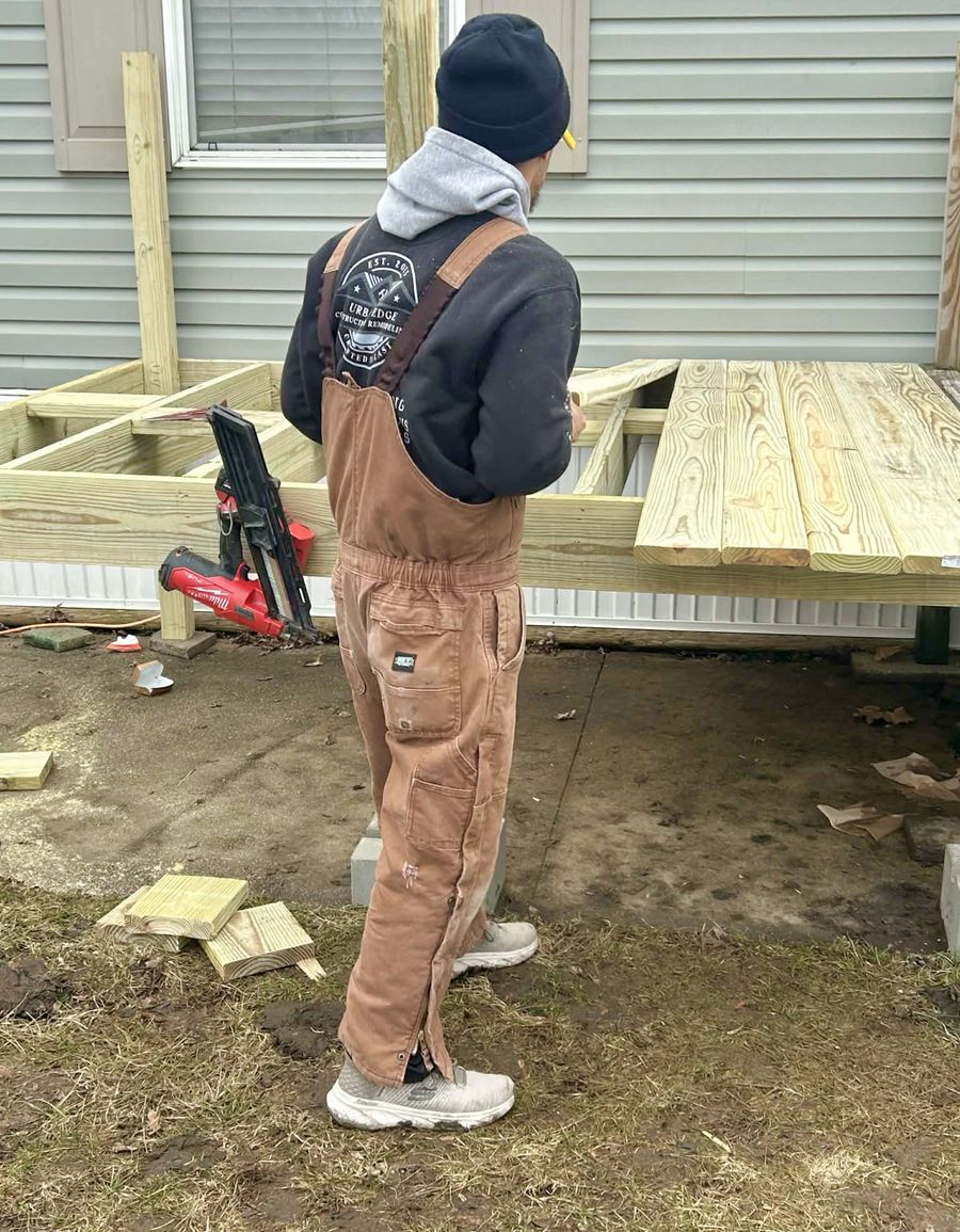 Matt building a new pressure-treated deck in Cedar Rapids, wearing his Urban Edge Construction & Remodeling sweatshirt