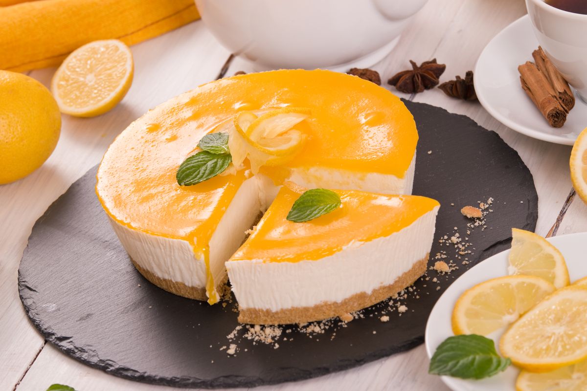 Lemon cheesecake on black dish.