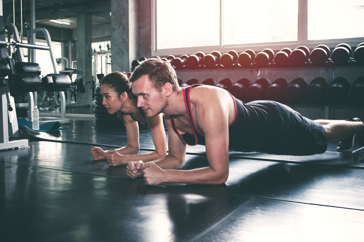 Couple or trainer teach or exercise in fitness gym with plank action