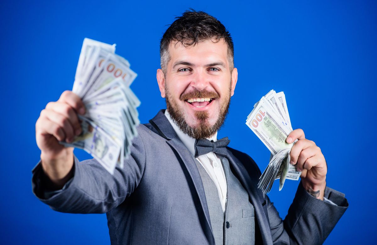 Investing to become rich. Business startup loan. Bearded man holding cash money. Making money with his own business. Currency broker with bundle of money. Rich businessman with us dollars banknotes.