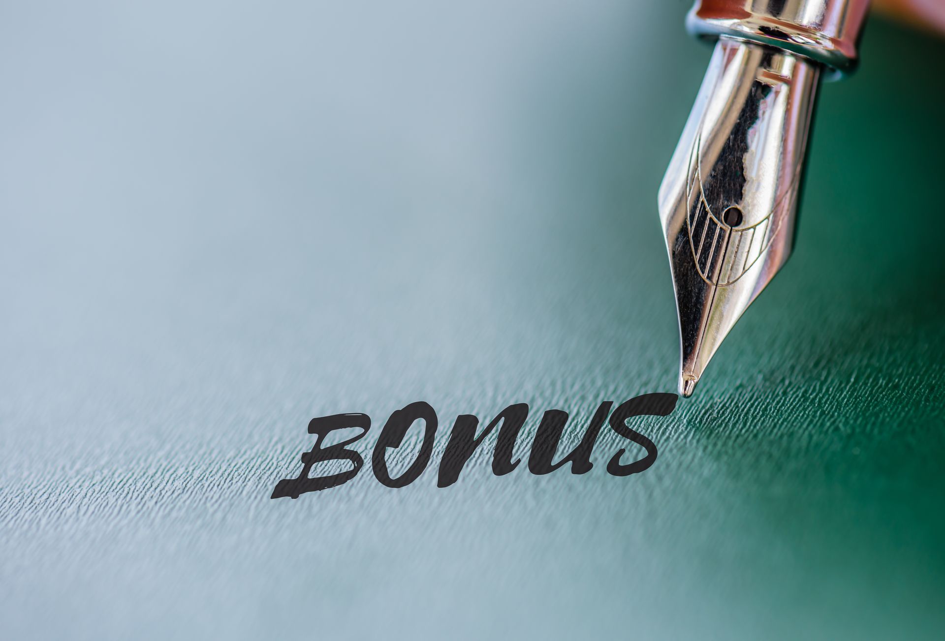 Abstract pen writing Bonus word on green board. Business achievement concept.