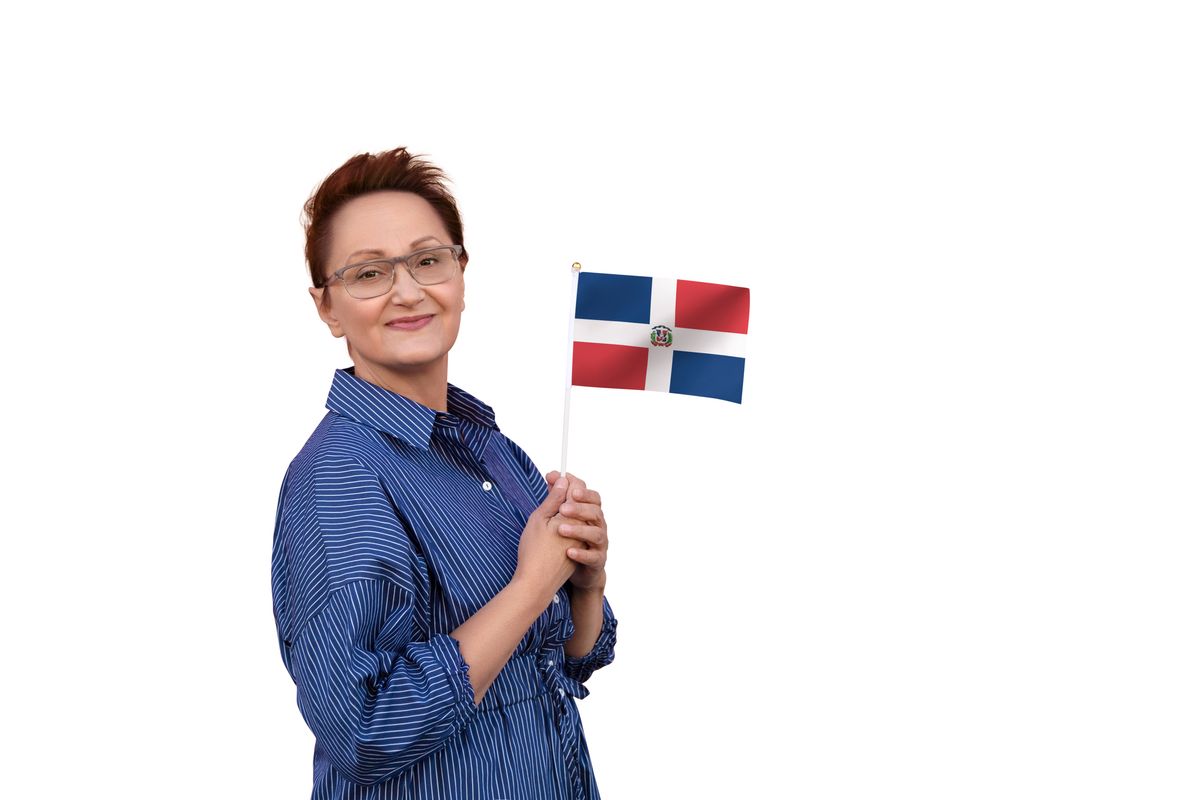 Dominican Republic flag. Woman holding Dominican Republic flag. Nice portrait of middle aged lady 40 50 years old with a national flag isolated on white background.
