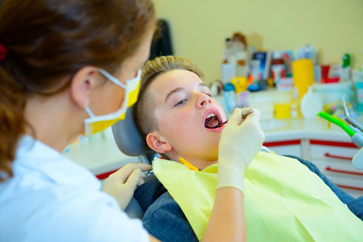 A teenager at a female dentist's surgery