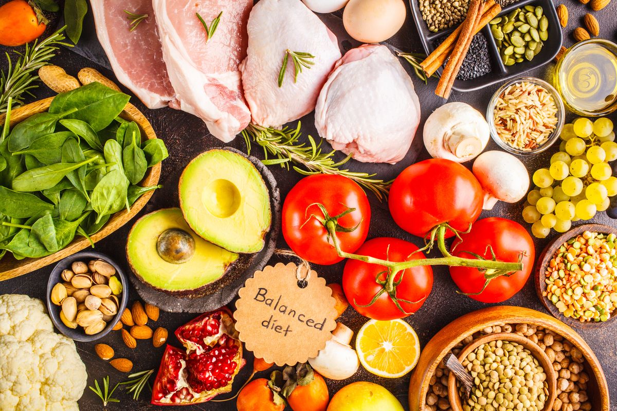 Balanced diet food background. Healthy ingredients: fruits, vegetables, meat, cereals and nuts on a dark background, top view.