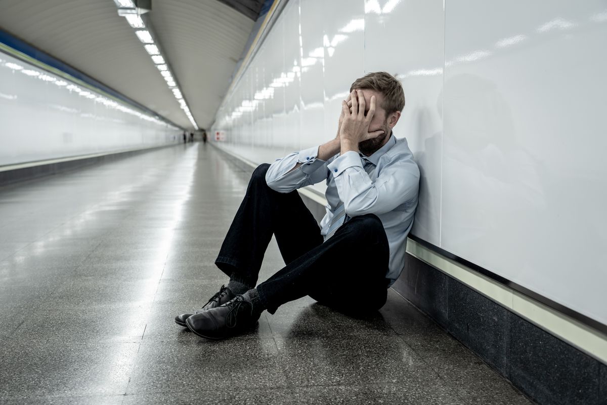 Desperate sad young businessman suffering emotional pain grief and deep depression sitting alone in tunnel subway in Stress life style Work problems failure Unemployment Mental health and Depression.