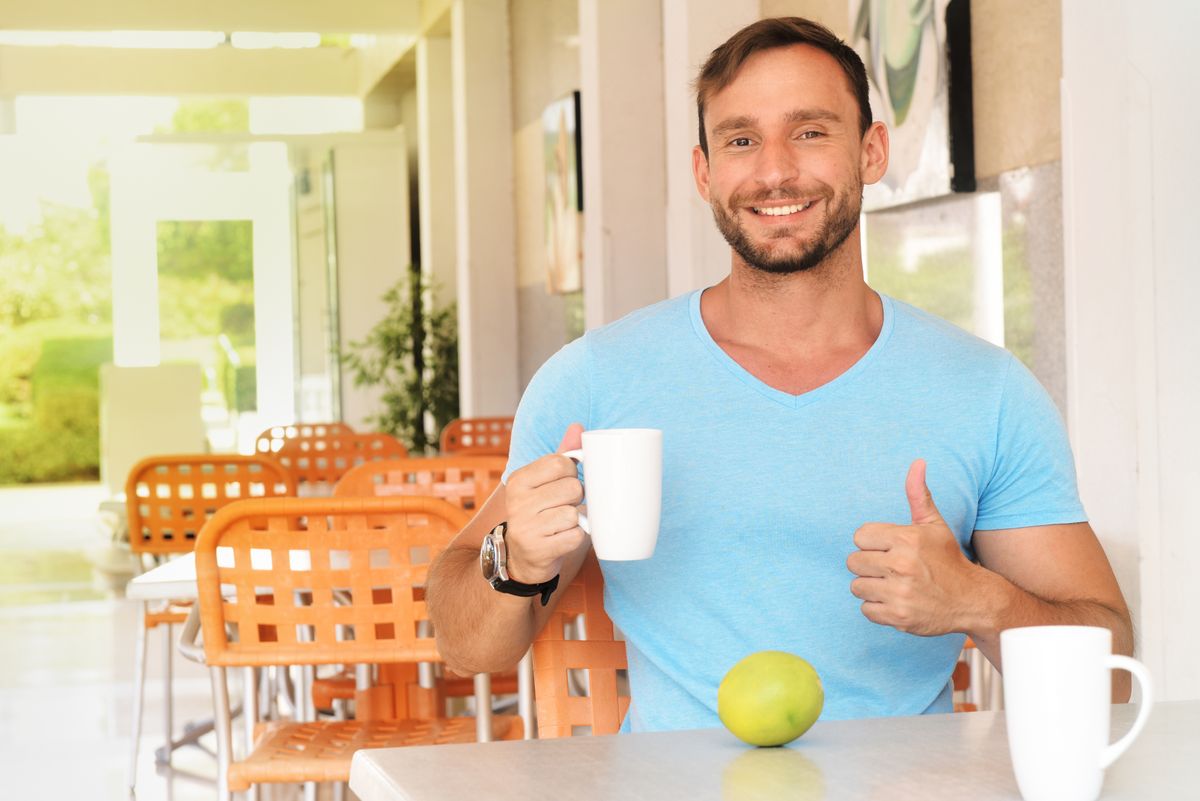 healthy attractive man drinking morning coffee or water, Fit male on a diet practices intermittent fasting and eating heathy foods. Handsome strong man living clean lifestyle as a vegetarian