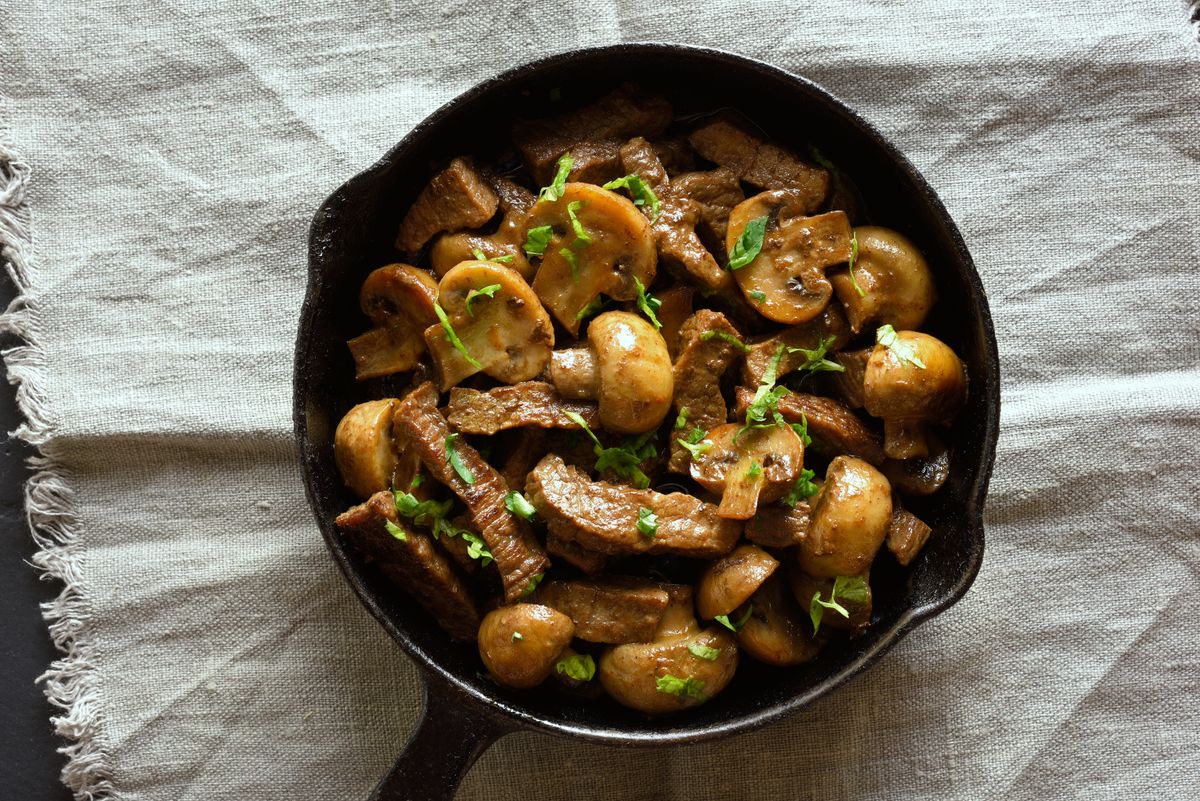 Close up of beef stroganoff with mushrooms in frying pan. Top view, flat lay