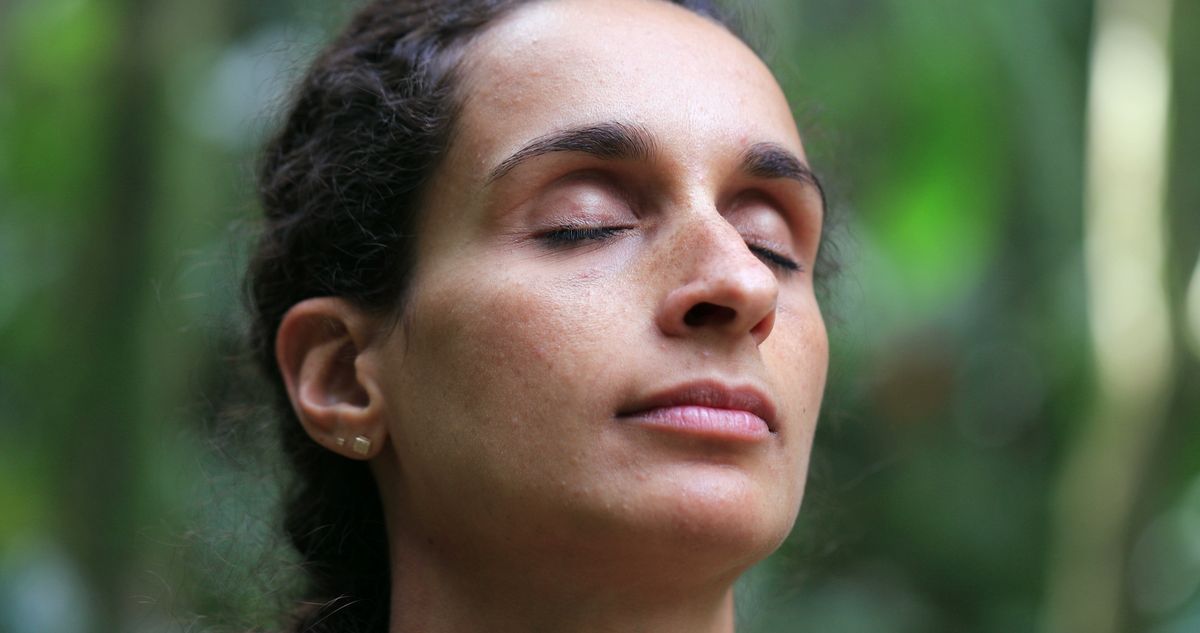 Woman meditating outdoors, taking a deep breath with eyes closed Woman meditating outdoors, taking a deep breath with eyes closed