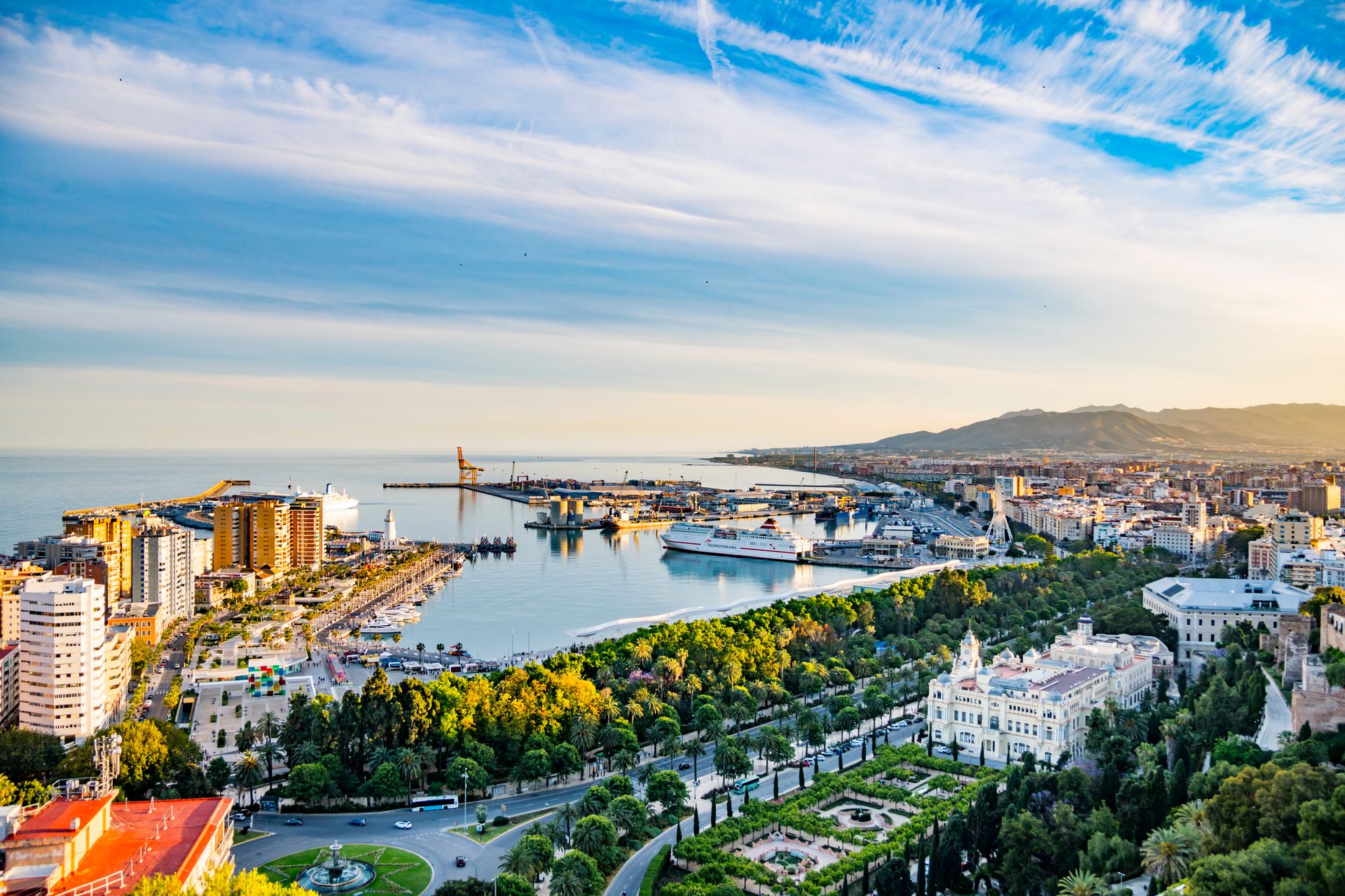 Picturesque cityscape view of Spanish city - Malaga with beautiful sky with clouds before sunset and during golden hour