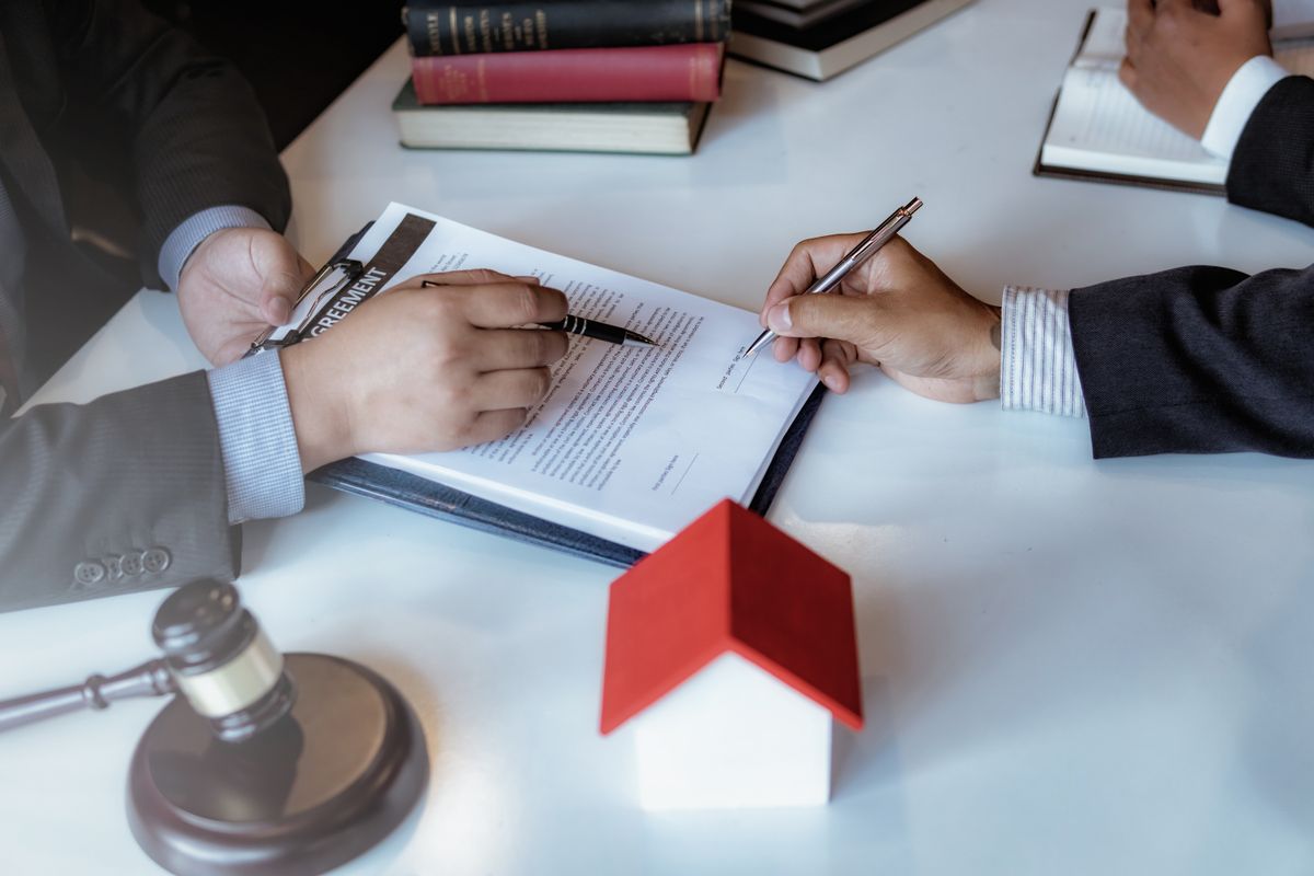 Lawyer sitting working at the desk hand holding pen for signing important documents. lawyer and law ,judiciary and legislature courtroom legal concept.