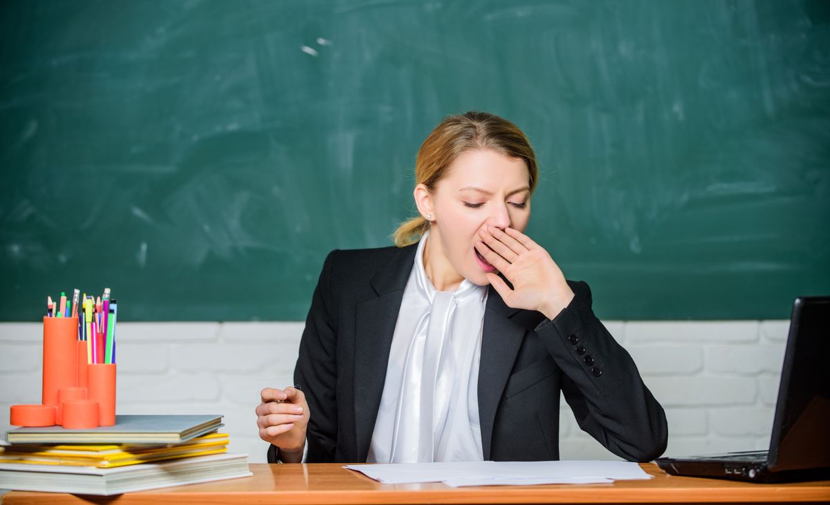 Need for sleep. High level fatigue. Exhausting work in school causes fatigue. Teacher woman sleepy face tired sit table classroom chalkboard background. Life of teacher exhausting. Yawning teacher.