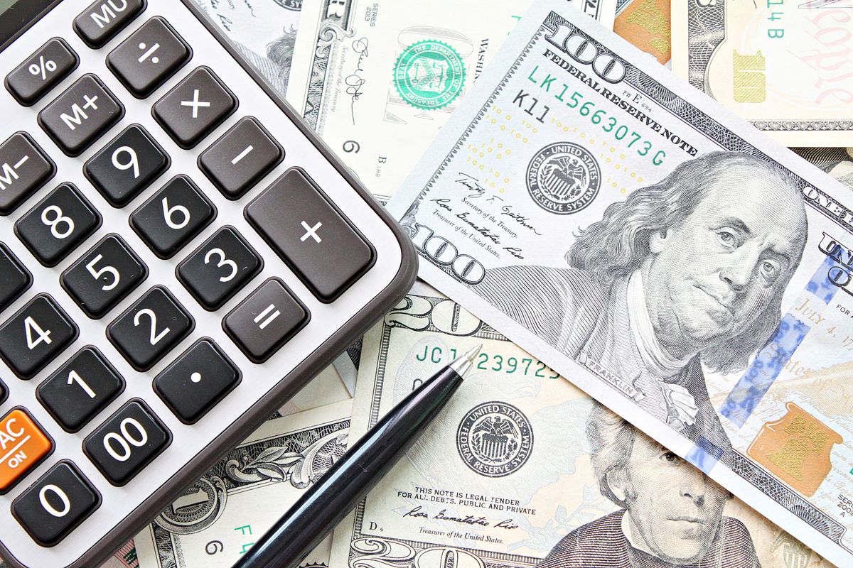 Business, finance, investment, accounting, taxes or money exchange concept : top view or flat lay of calculator and pen on American Dollars cash money 