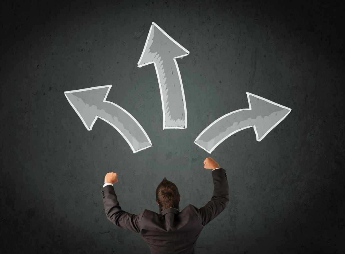 Young businessman taking a decision with different directed arrows above his head Young businessman taking a decision with different directed arrows above his head